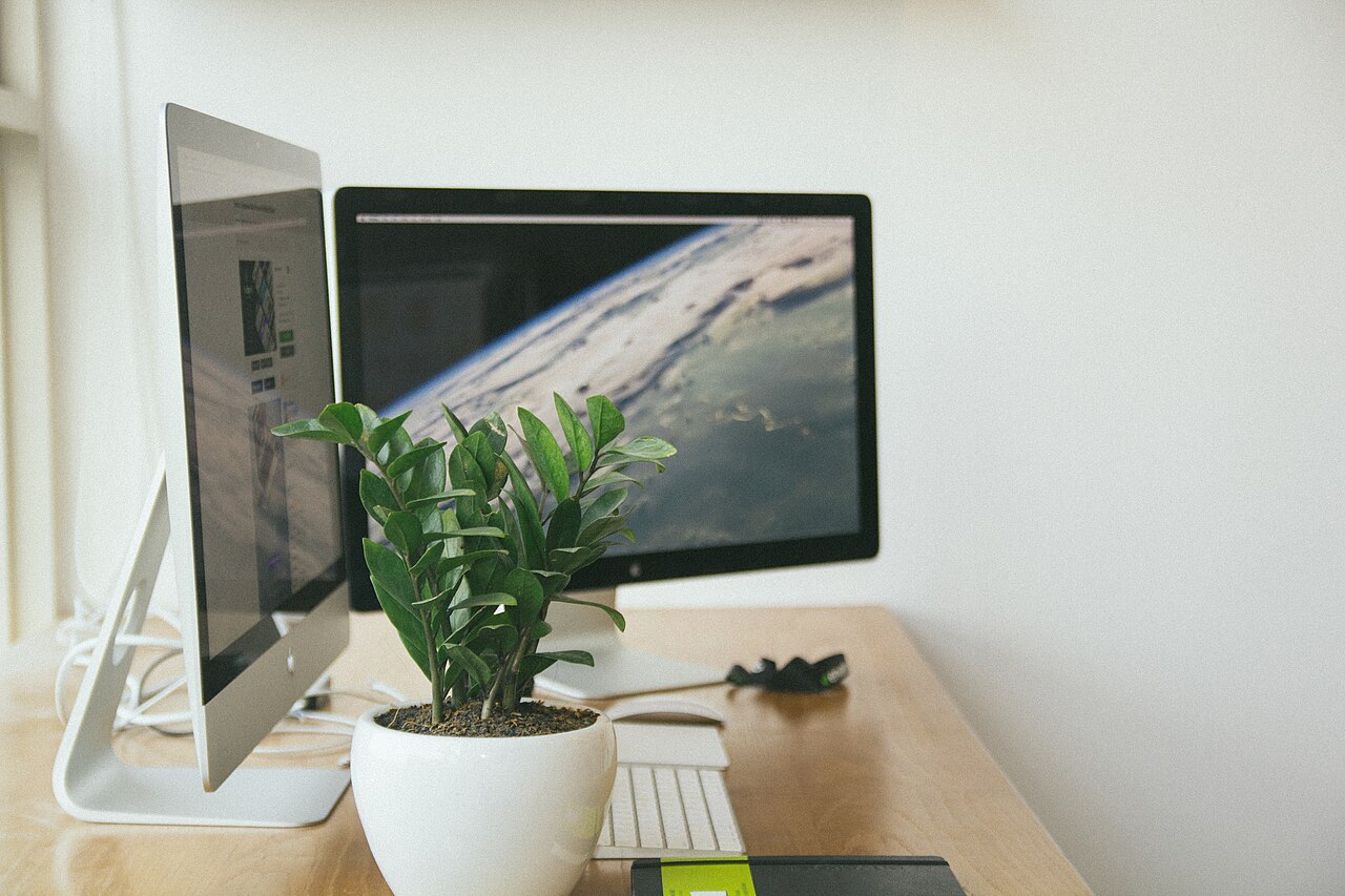 A desk with two computer monitors in an office
