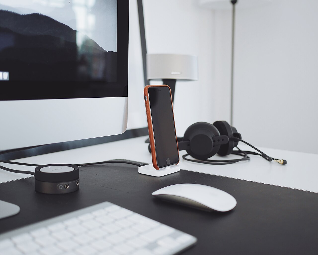 A computer desk with a lamp and a monitor