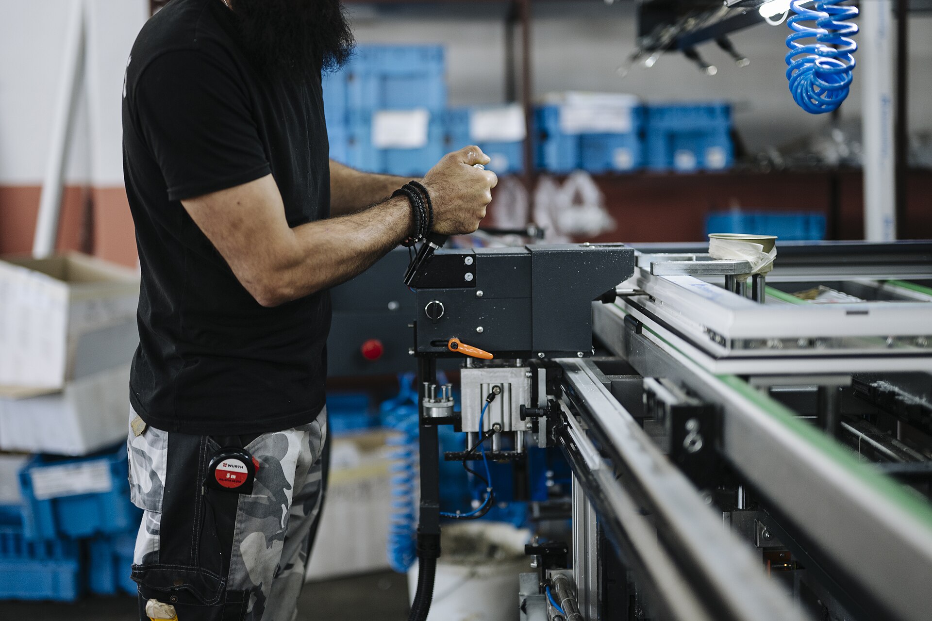 A worker standing beside machinery in a factory