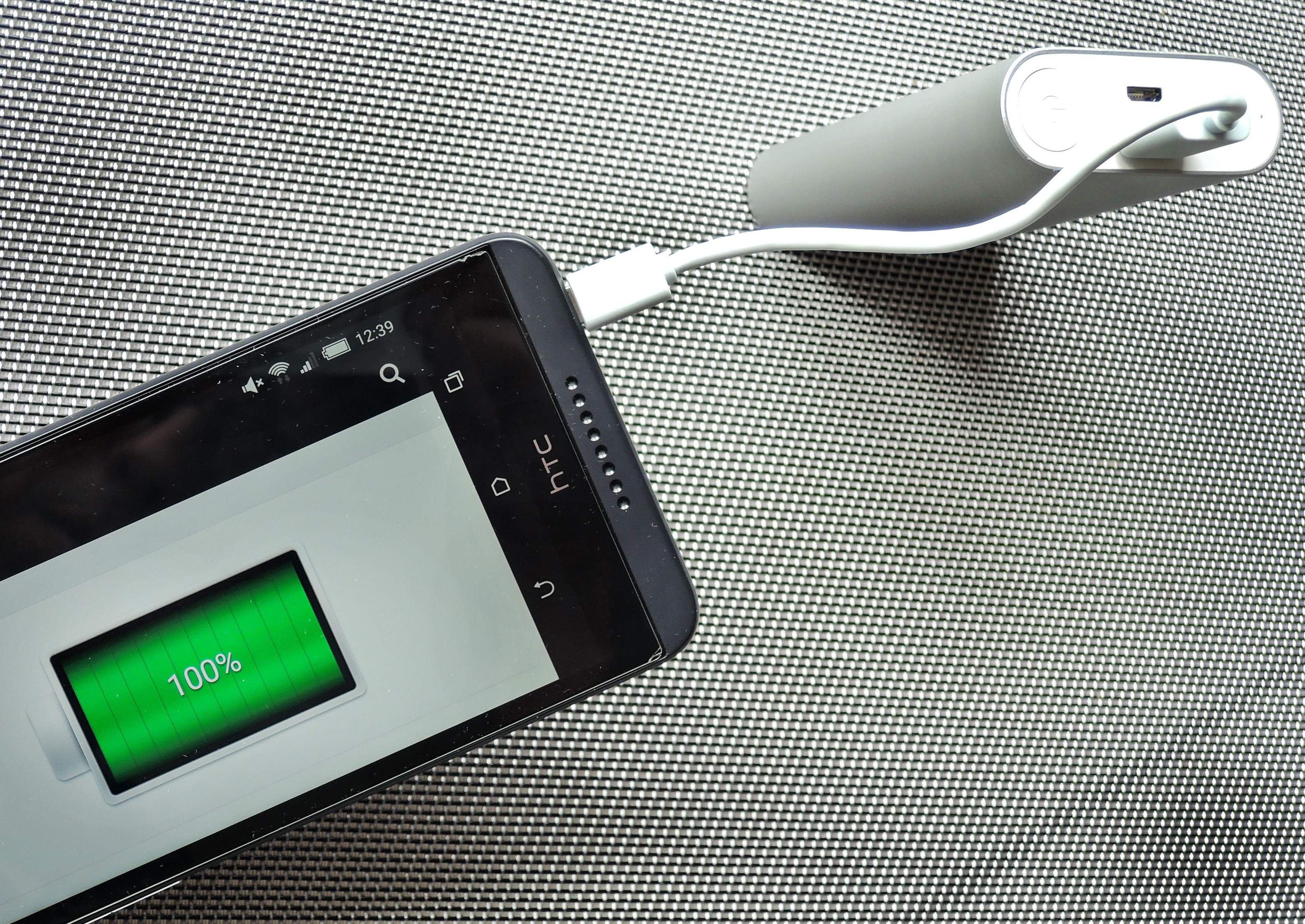 A phone charges from a USB power bank