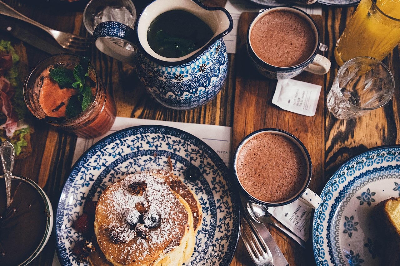 A breakfast table with pancakes and coffee