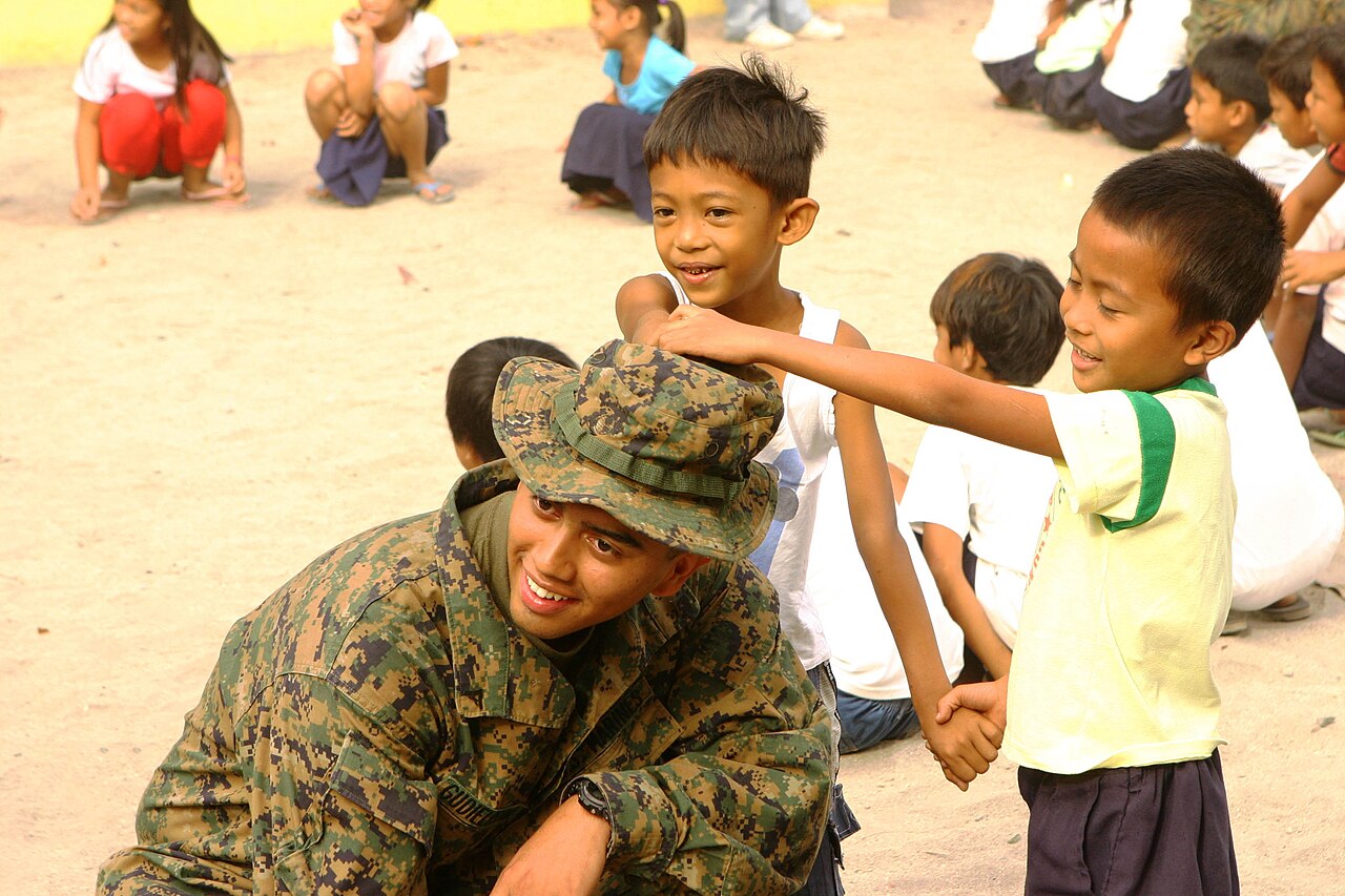An adult playing a game with children outdoors