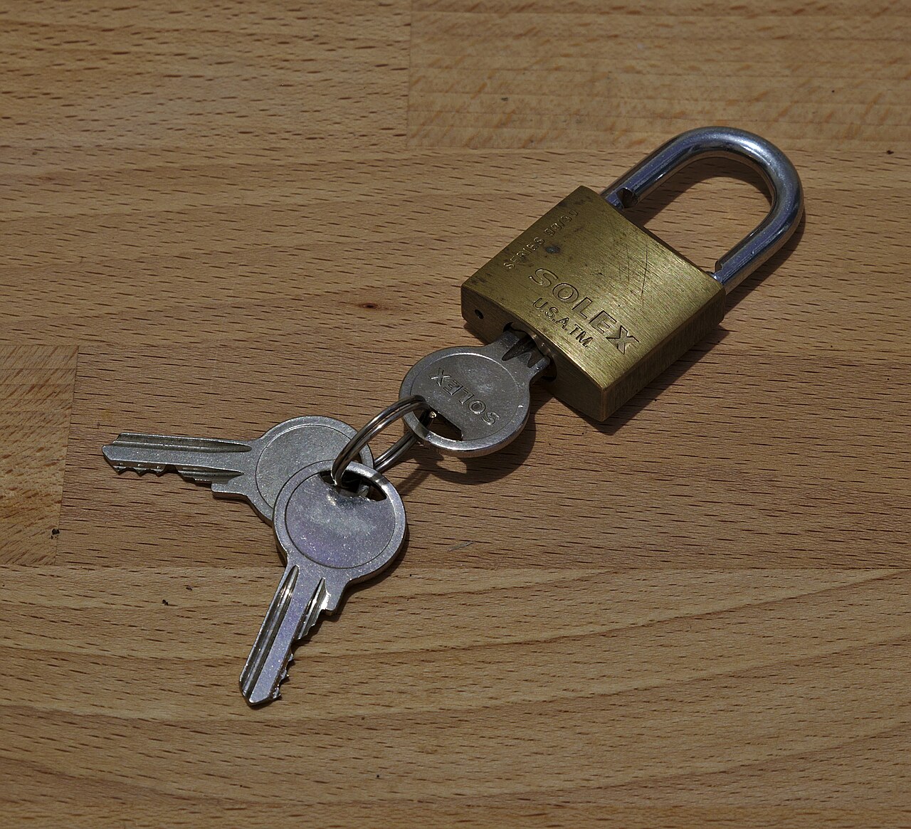 A padlock with its keys lying beside it