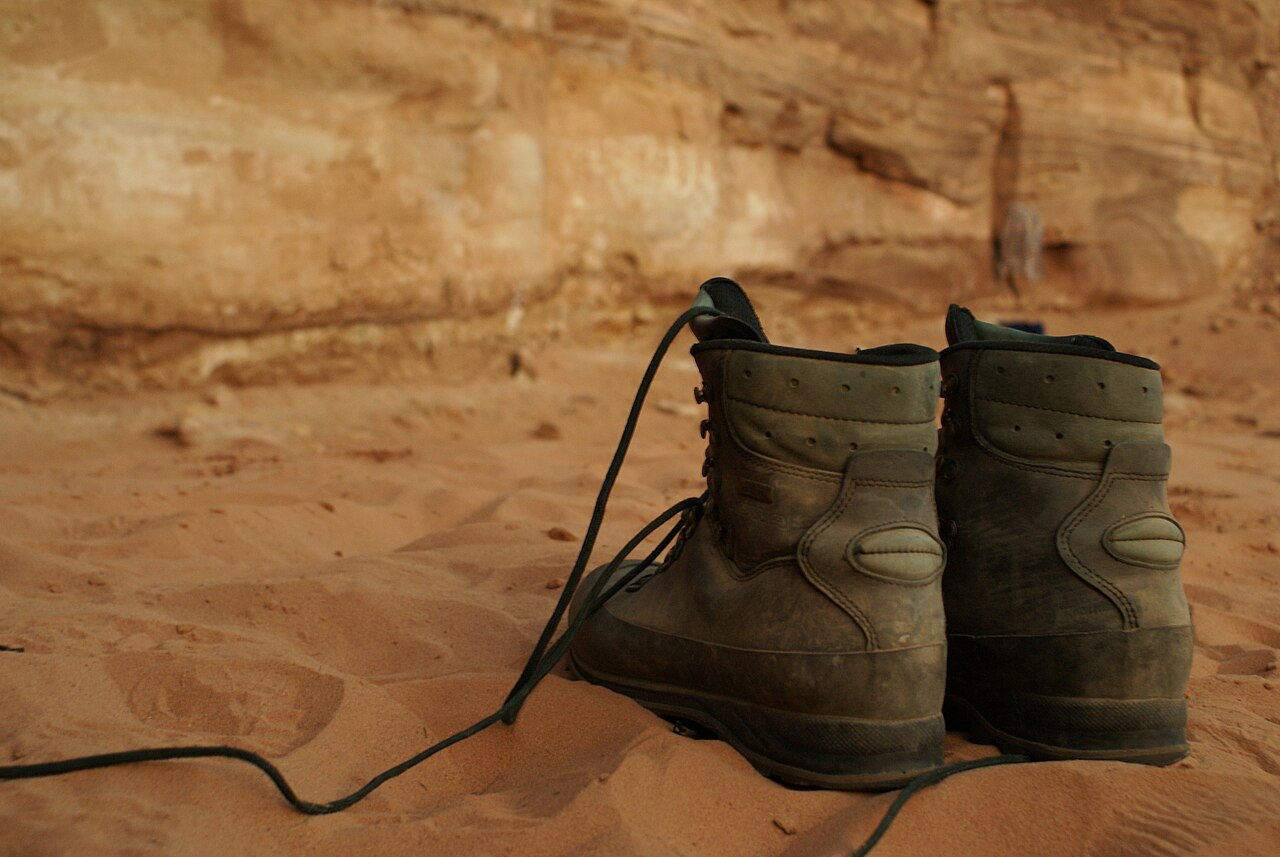 Hiking boots resting on sand during a break