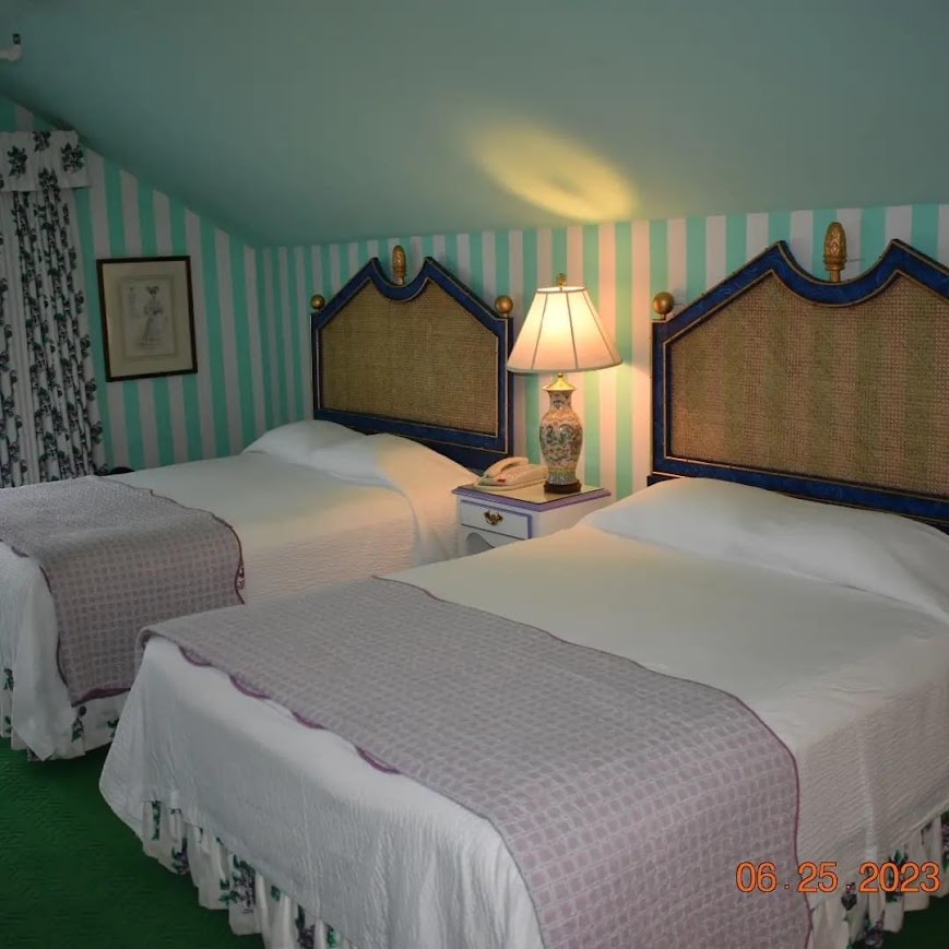 A tidy hotel room with a made bed and a window