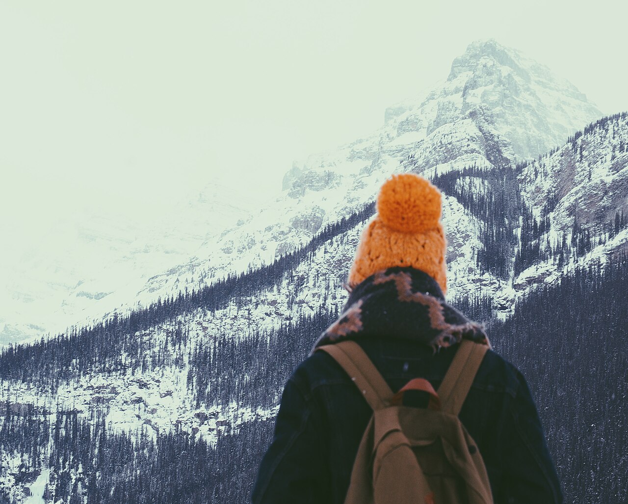 A hiker walking on a snowy mountain slope