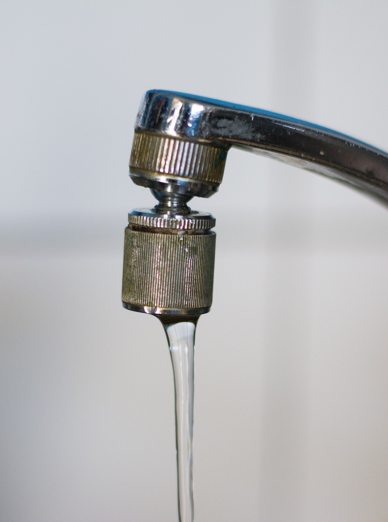 A household water tap running into a sink