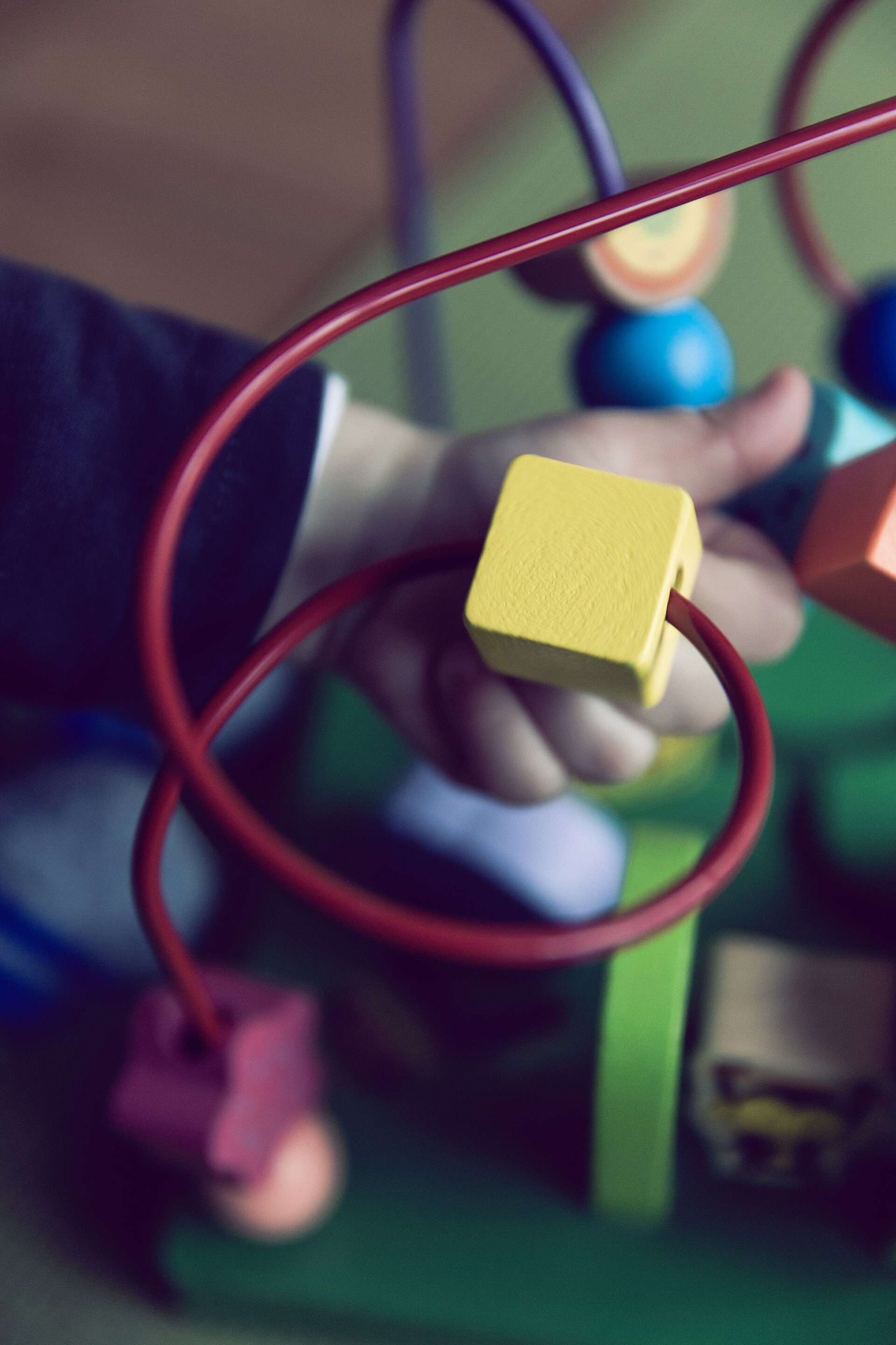 A toddler playing with a wire bead toy