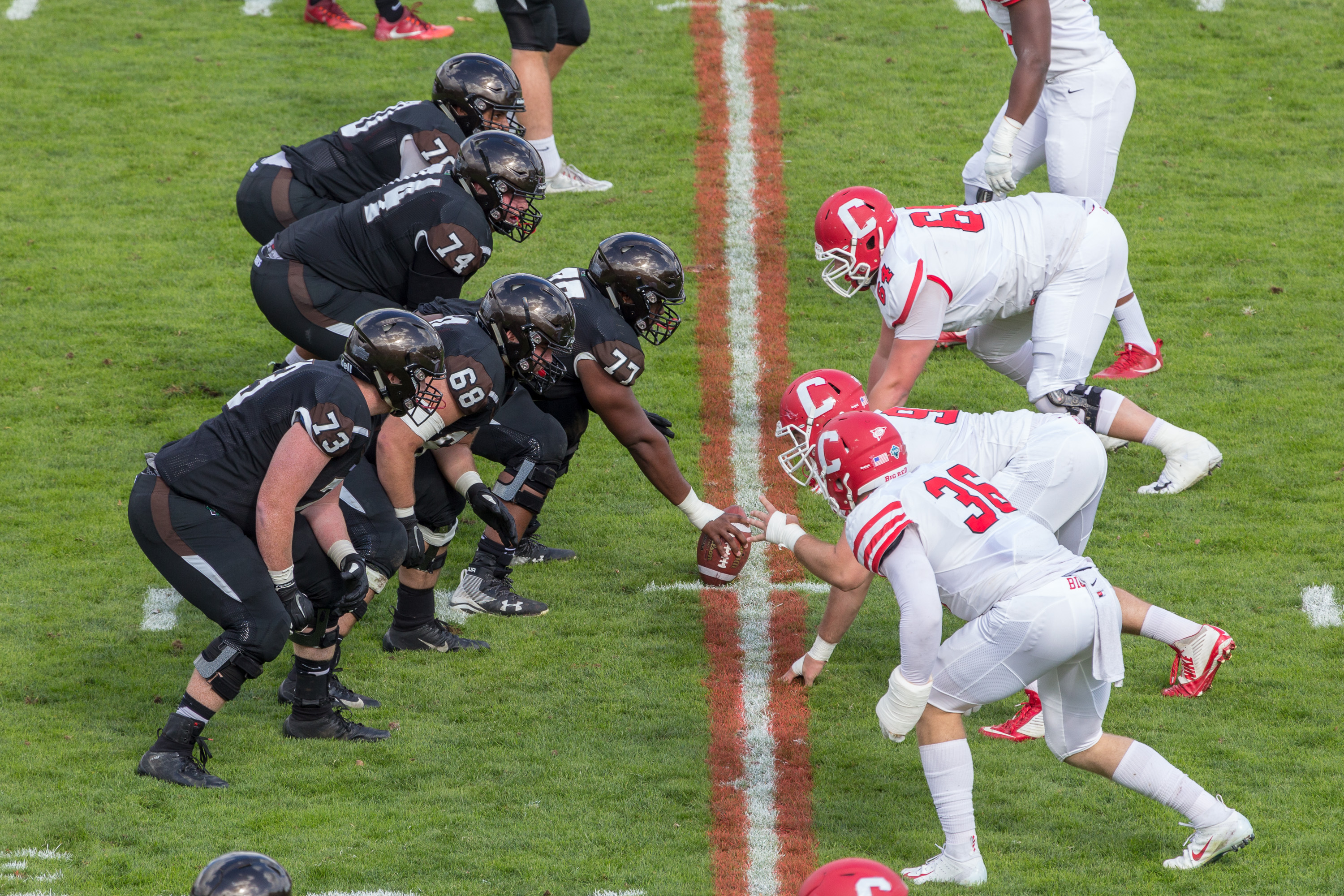 A college football game in progress, with players lined up at the line of scrimmage