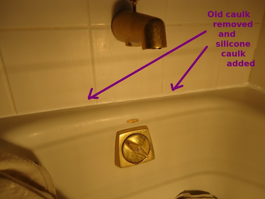Fresh silicone caulk sealing the joint between a bathtub and wall tiles