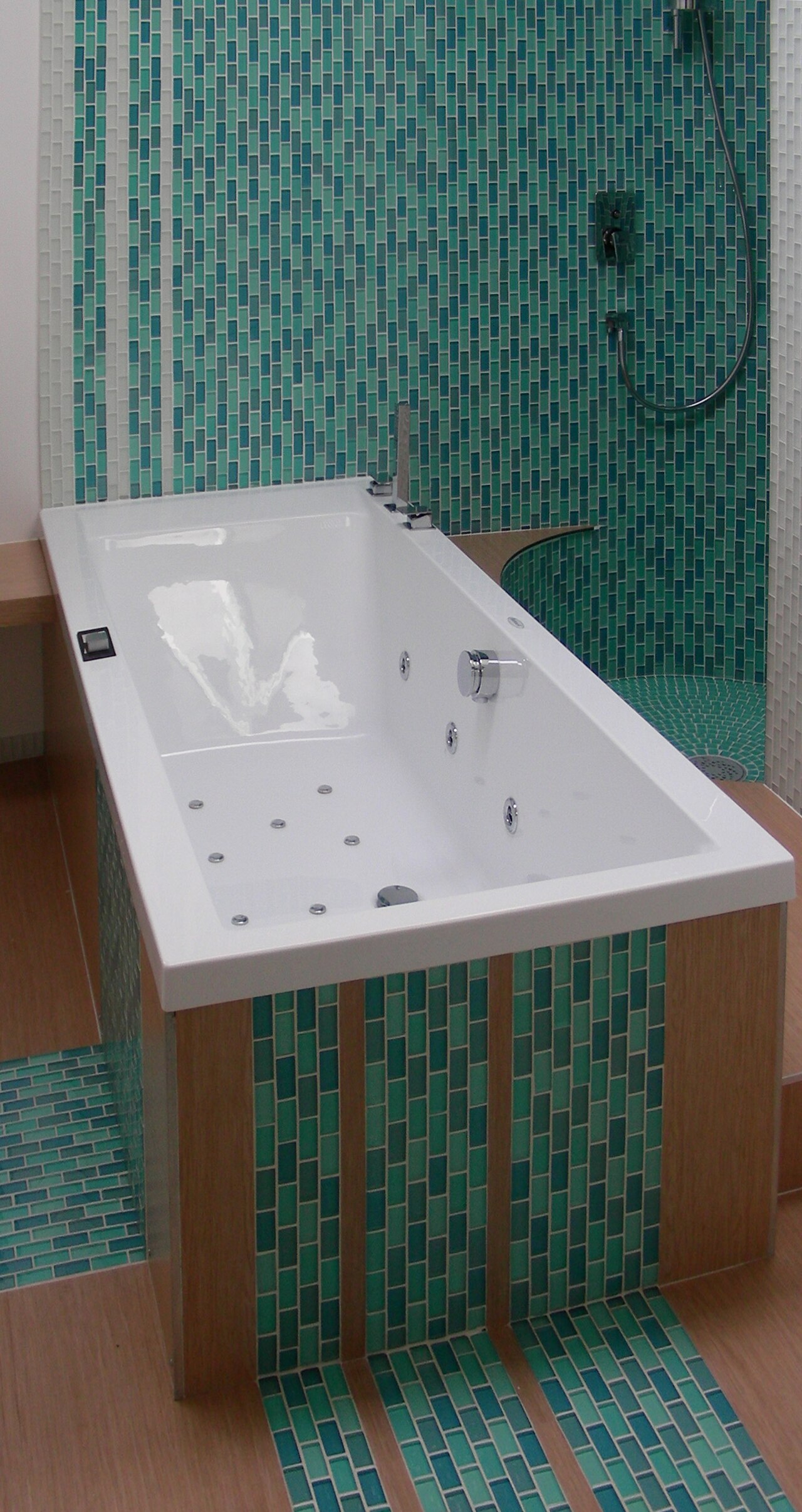 A bathtub in a tiled bathroom, the kind of seam that needs a fresh caulk bead