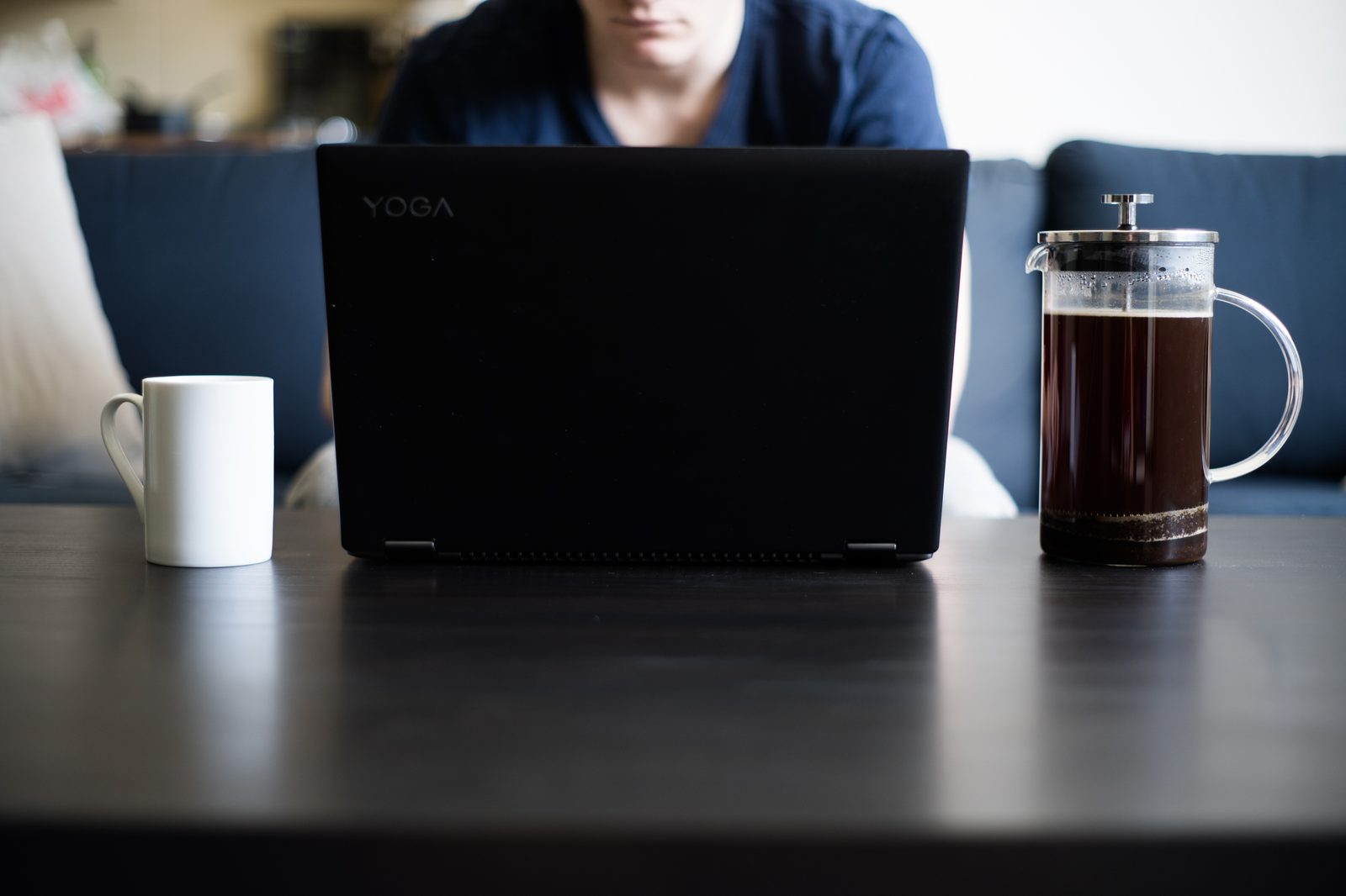 Person working from home with a laptop and coffee