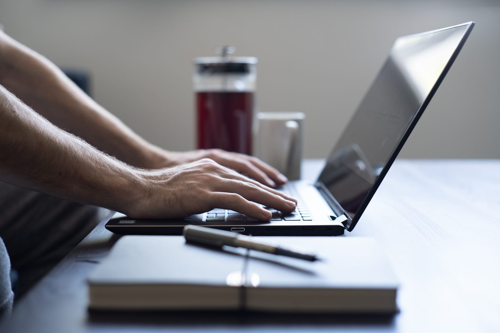 Person working from home with a laptop and notepad