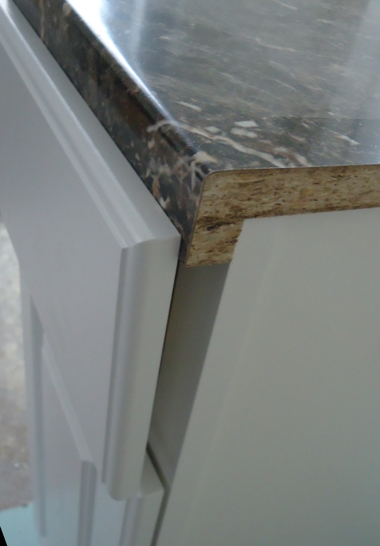 A cabinet drawer front that does not sit flush under a countertop