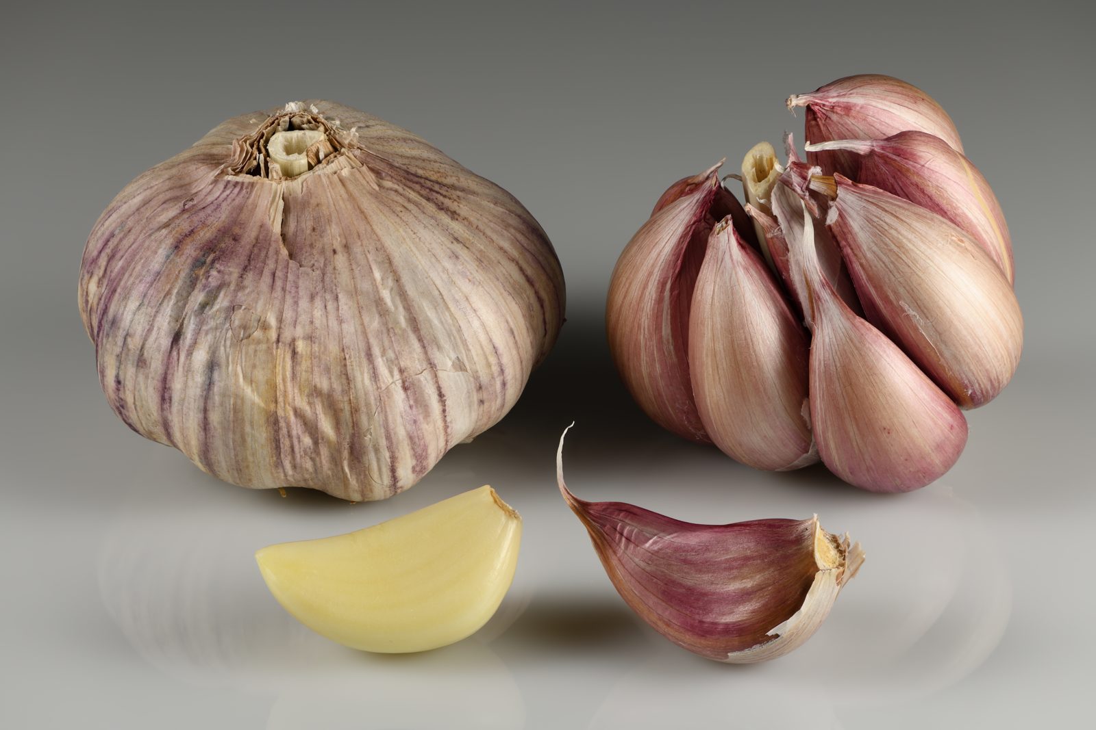 Fresh garlic bulbs with white papery skins beside loose cloves