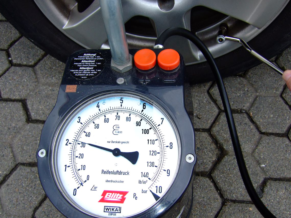 Checking tyre pressure with a gauge