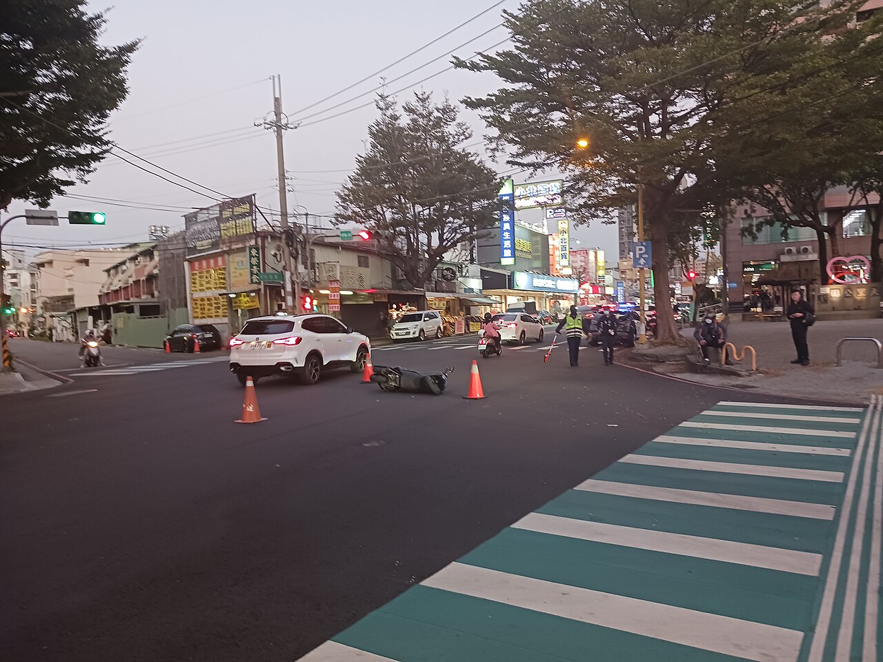Police and traffic cones at the scene of a scooter accident on a city street