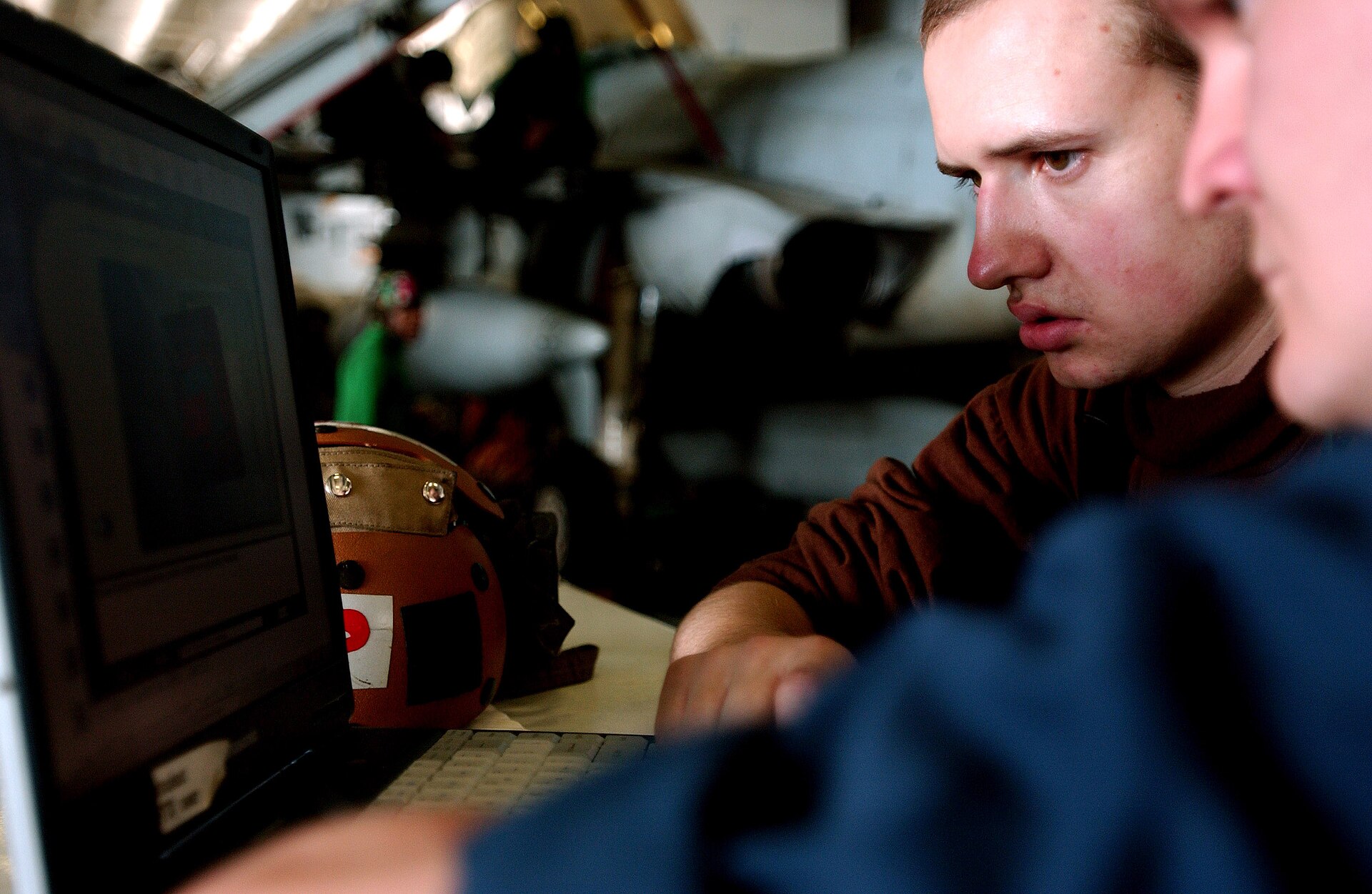Two service members studying safety precautions on a laptop