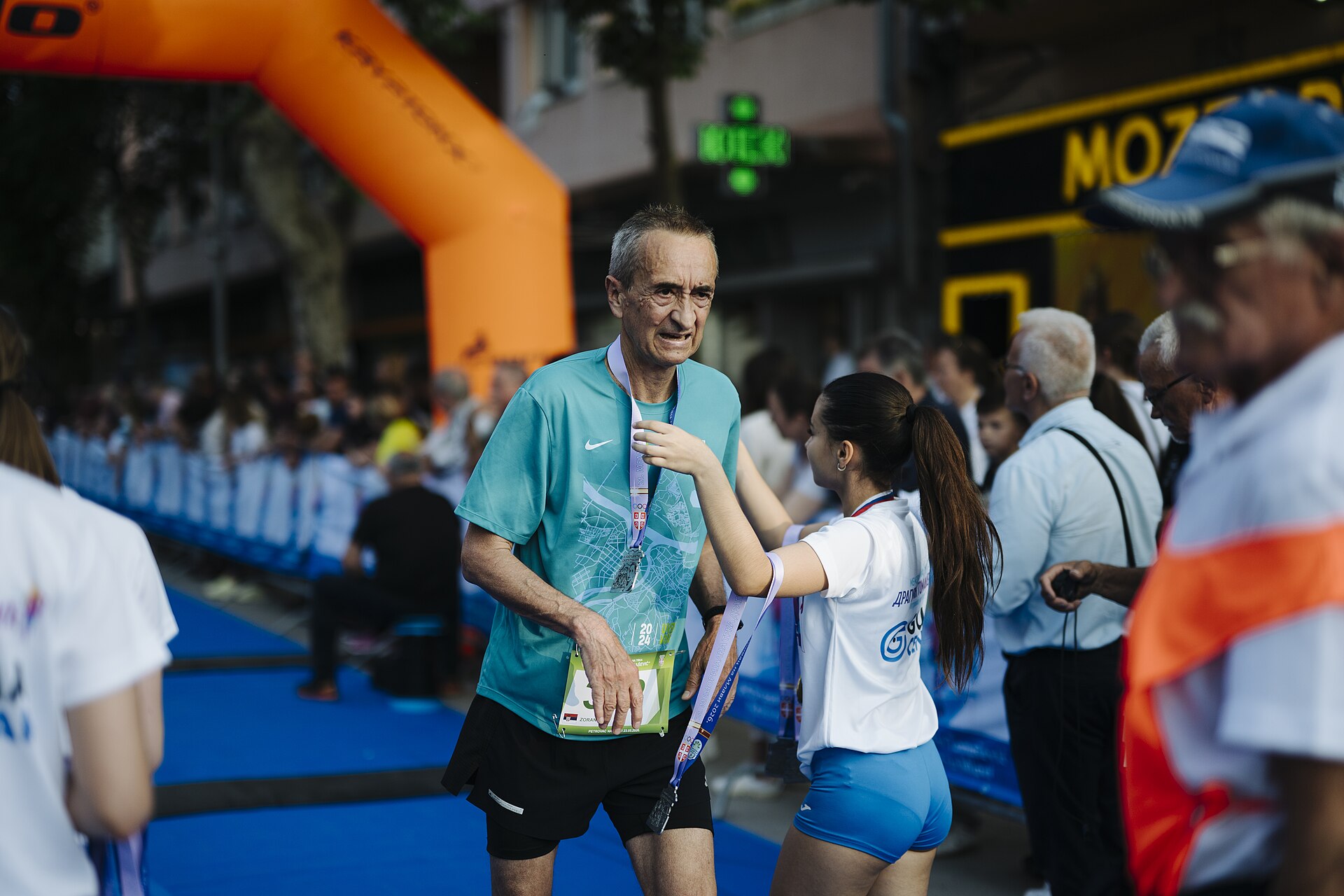 A runner receiving a medal at a finish line