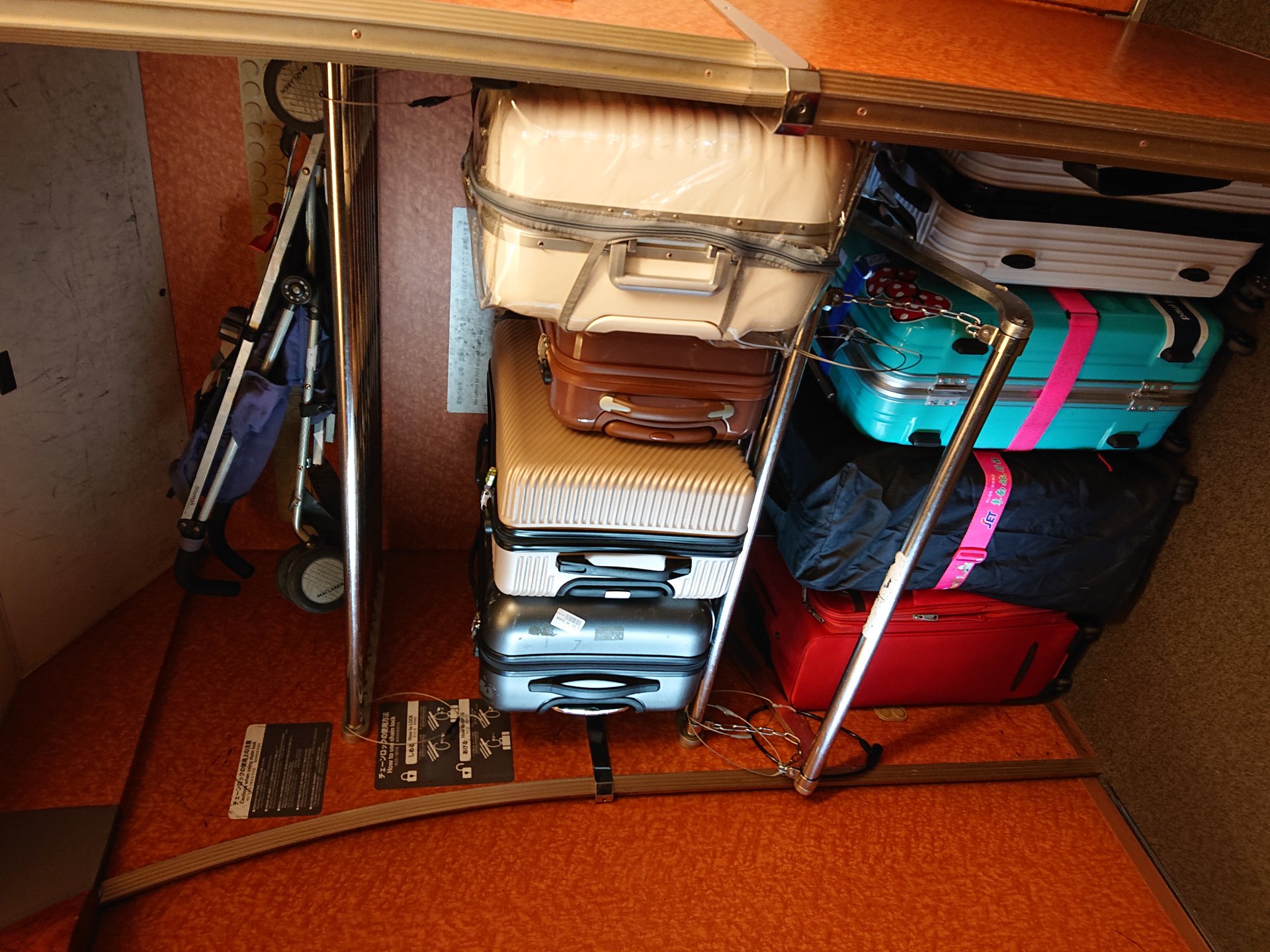 Suitcases sit in a luggage rack inside a train carriage