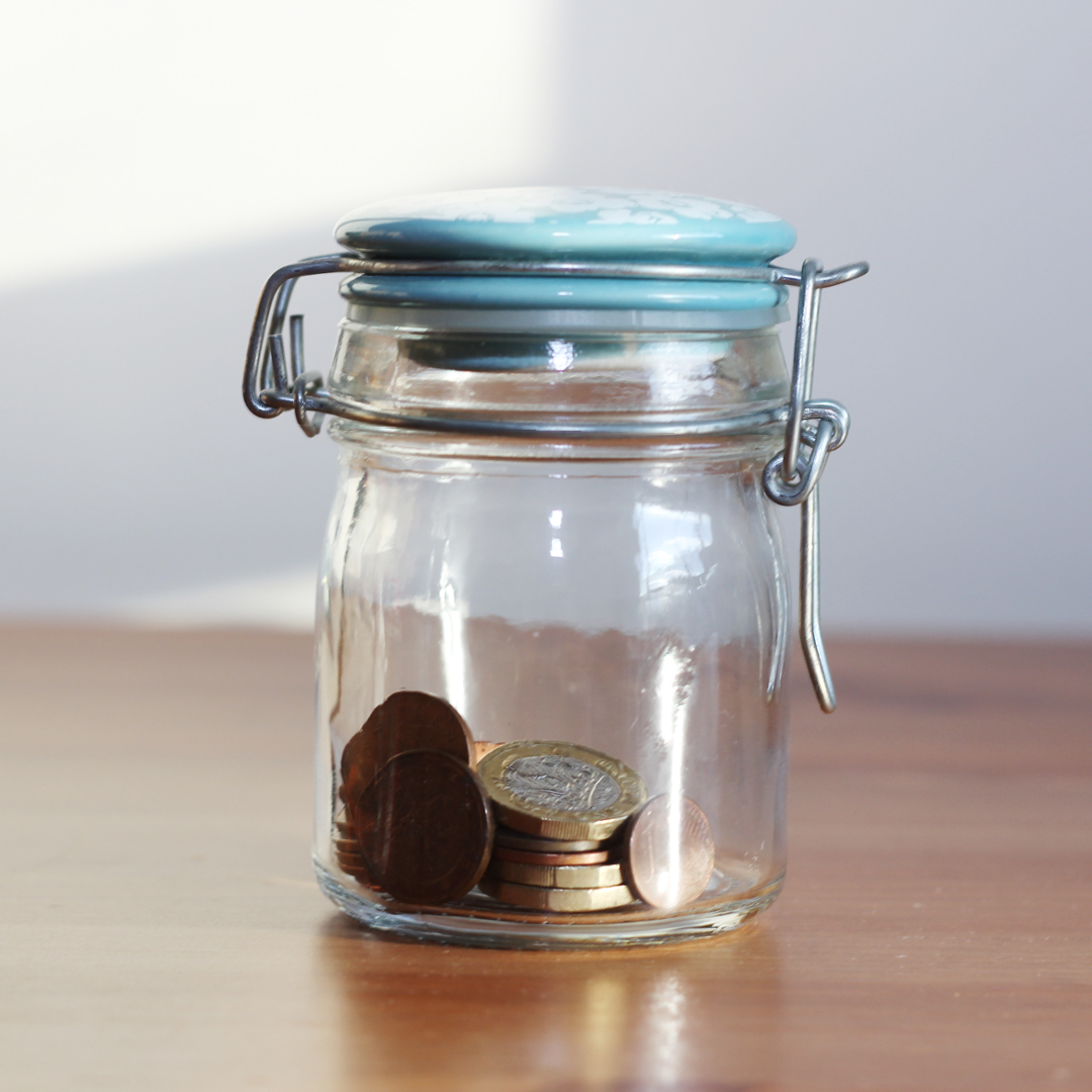 Coins stacked beside a small plant, a common image of saving