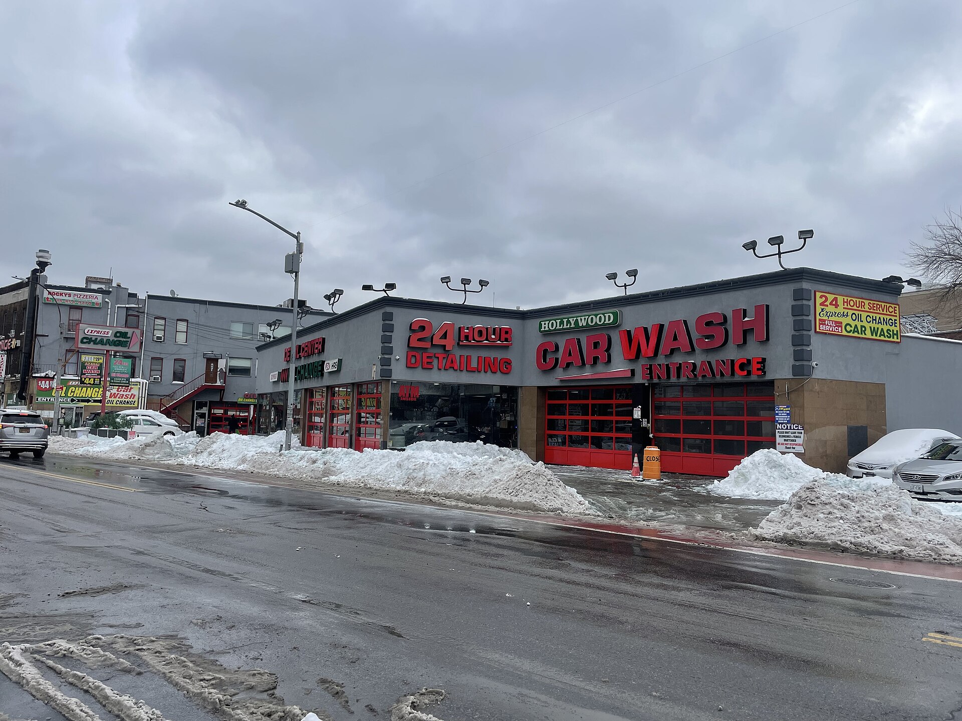 A car wash building with snow piles along a city street