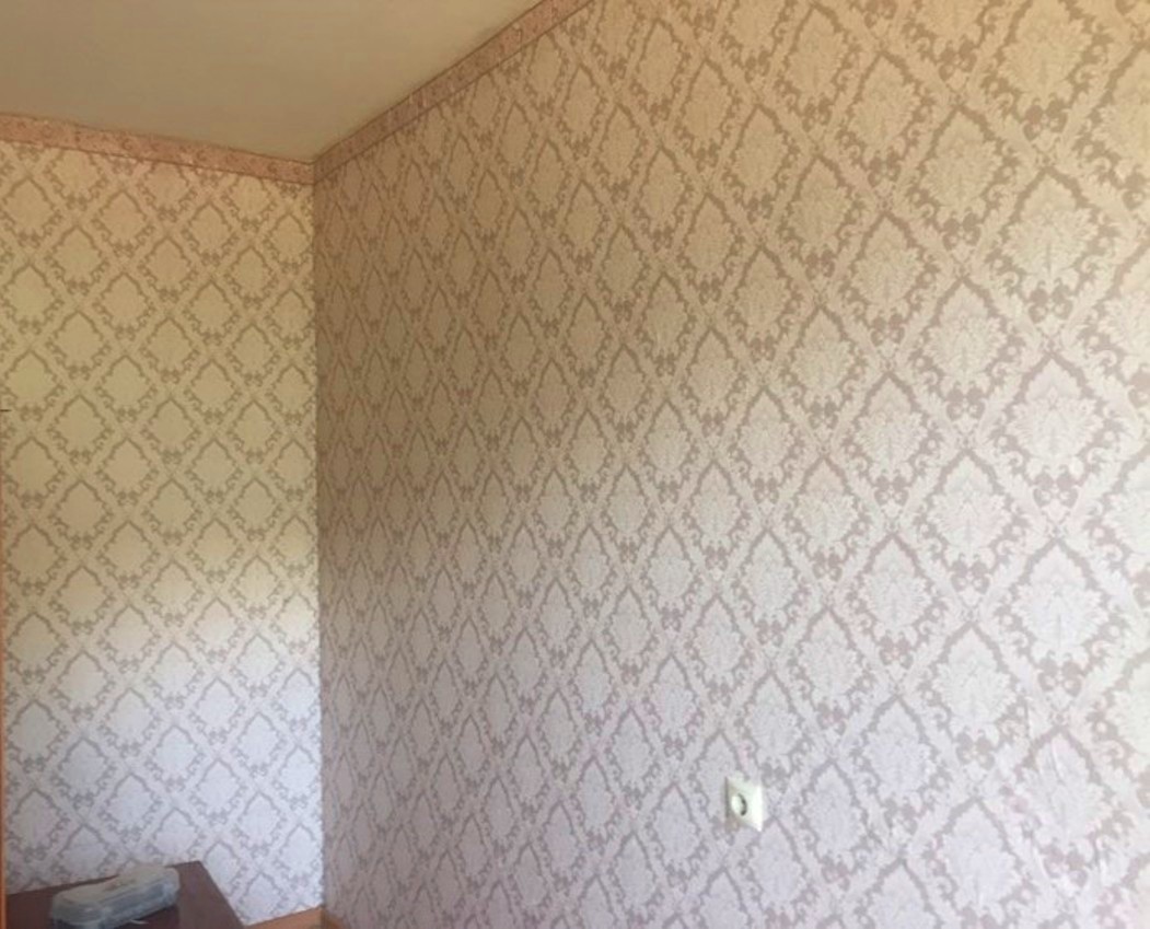 Old wallpaper on an apartment wall, ready for removal