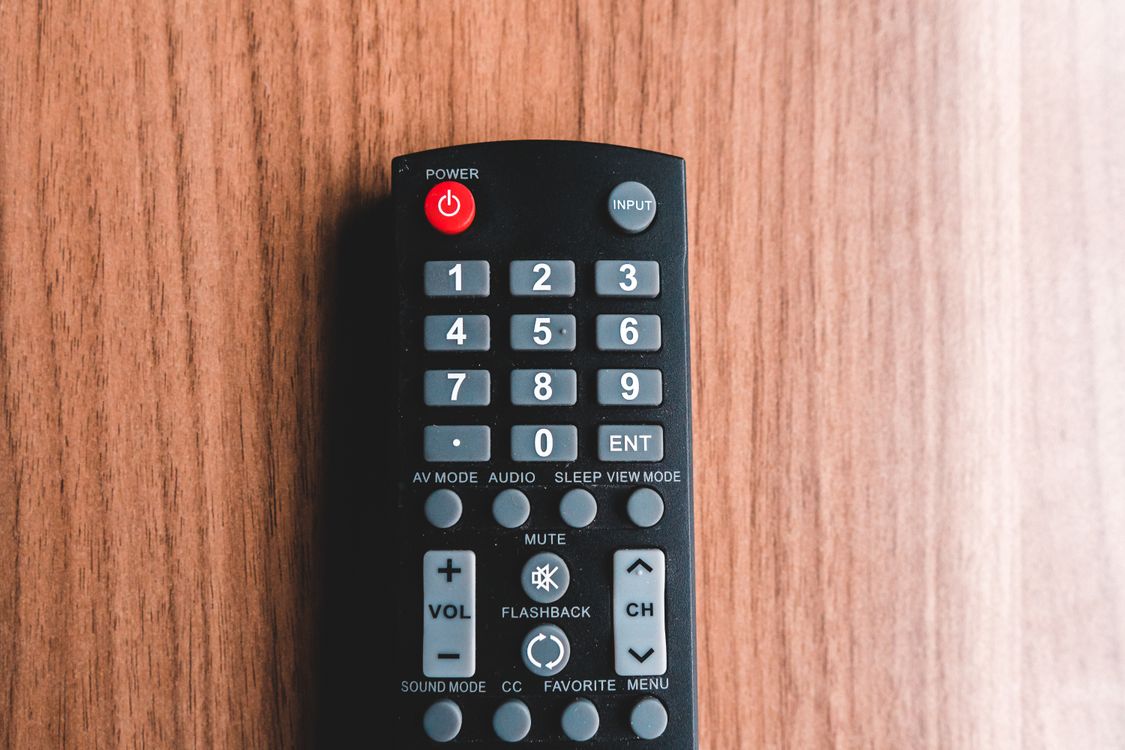 A television remote control on a wooden surface