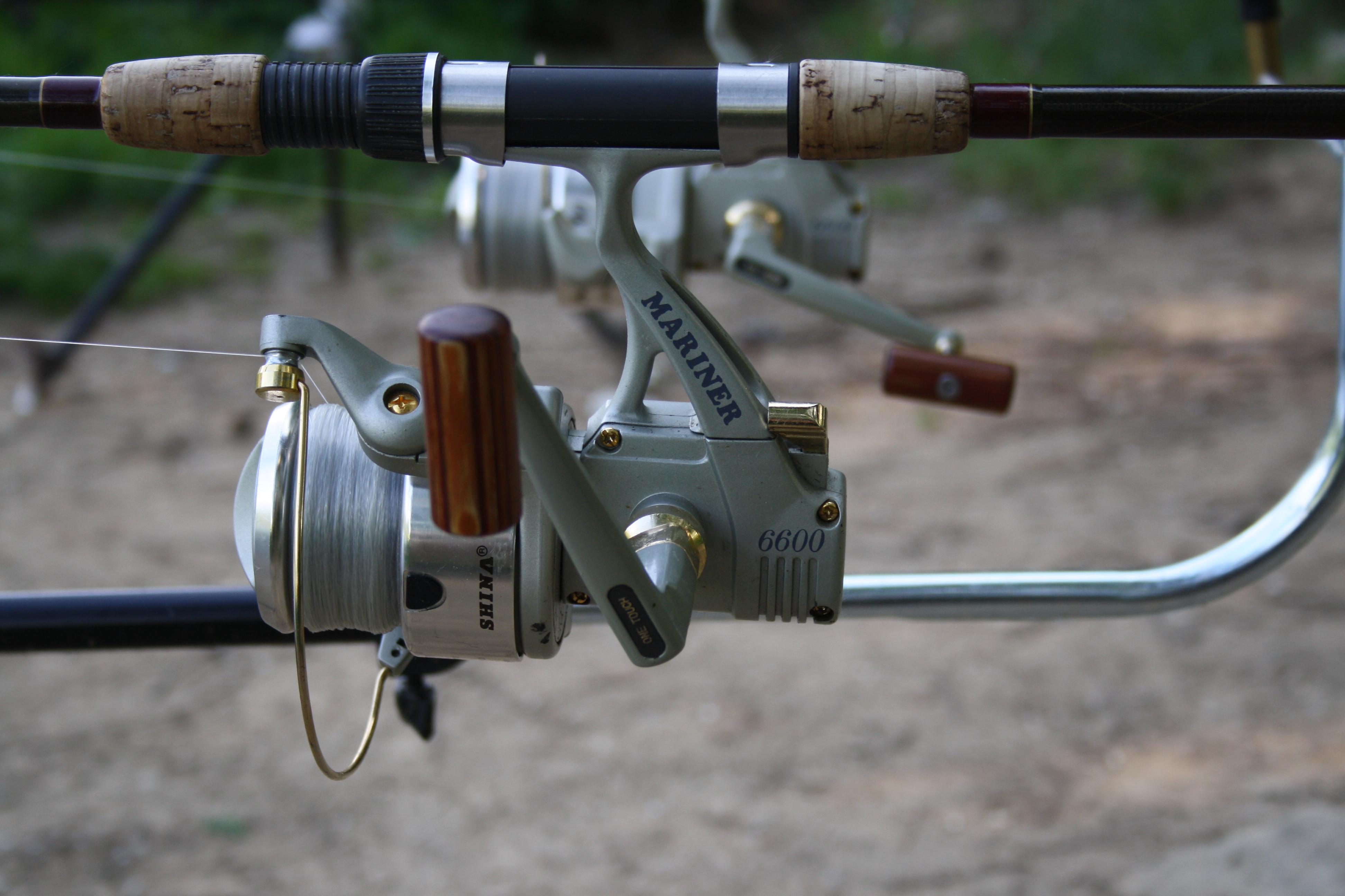 A close view of a spinning reel mounted on a fishing rod