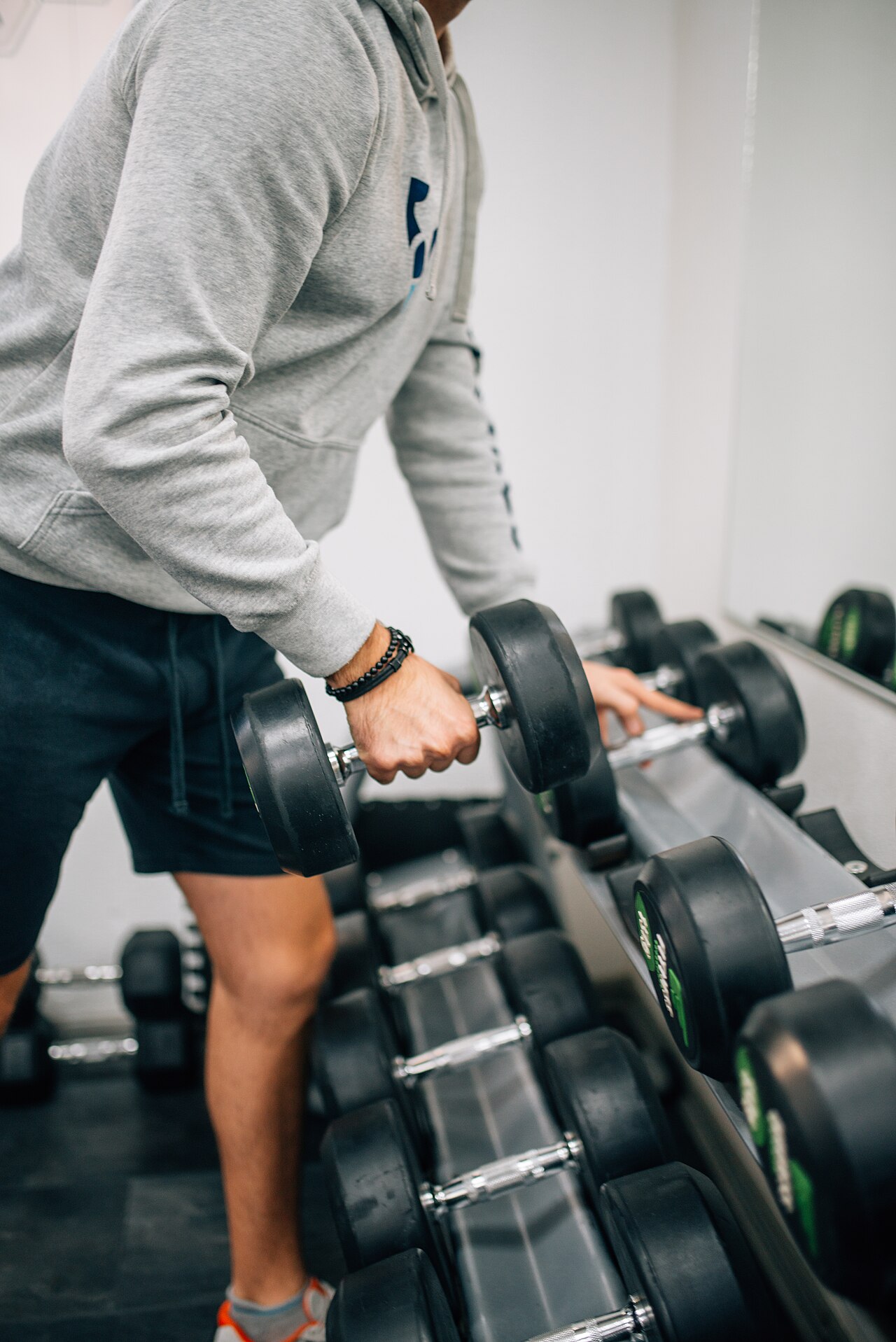 A man lifts a dumbbell during a workout in a gym