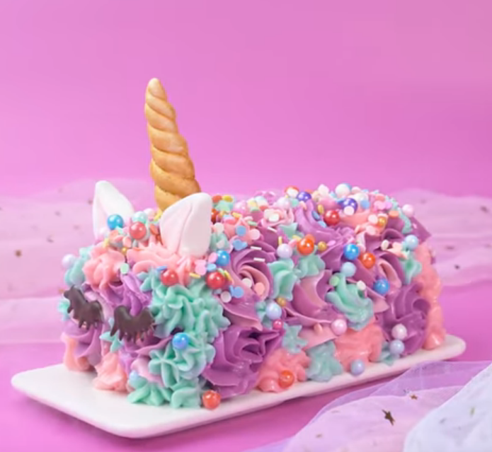 A unicorn cake covered in pastel frosting swirls and sprinkles