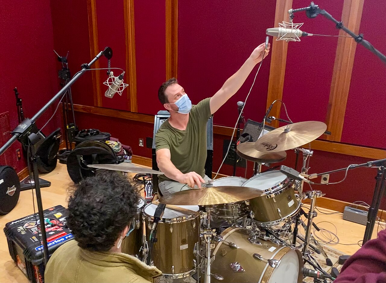 A person measuring the distance to a microphone in a studio