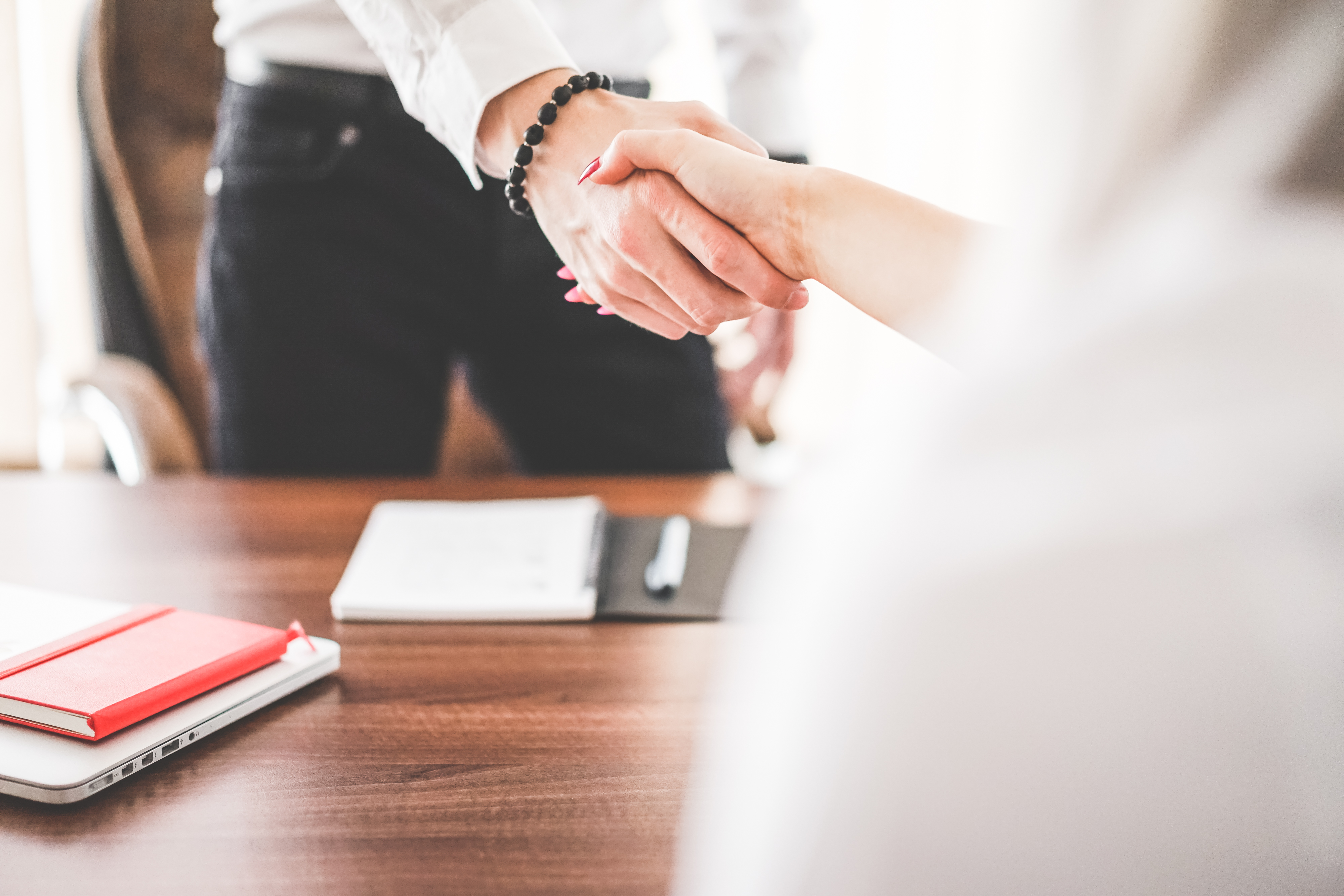 Two people shaking hands after a meeting in an office