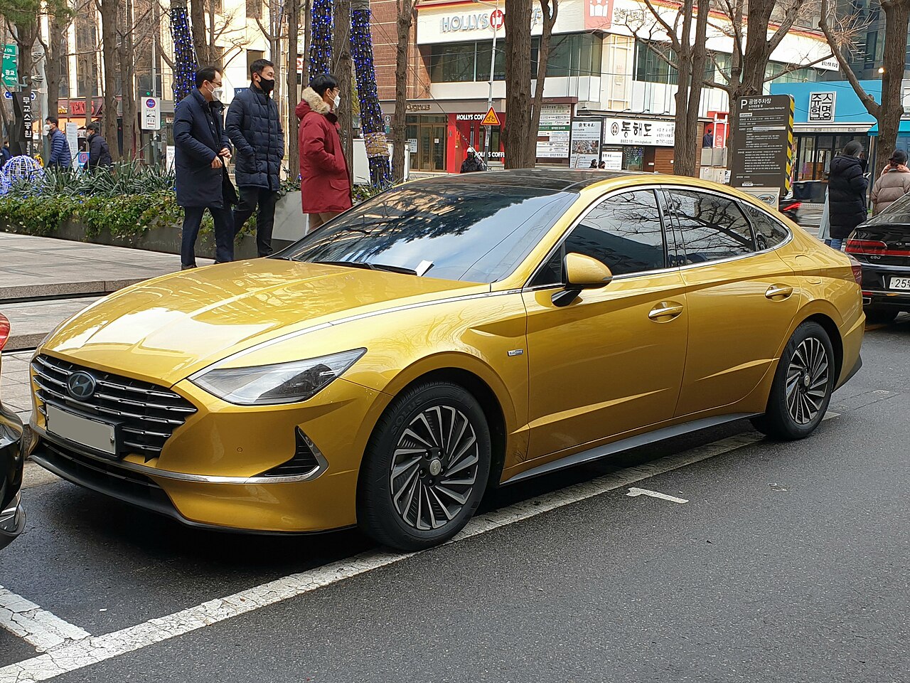 A yellow hybrid sedan parked on a street