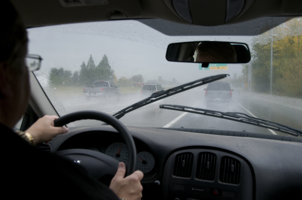 A car drives in rain on a wet road