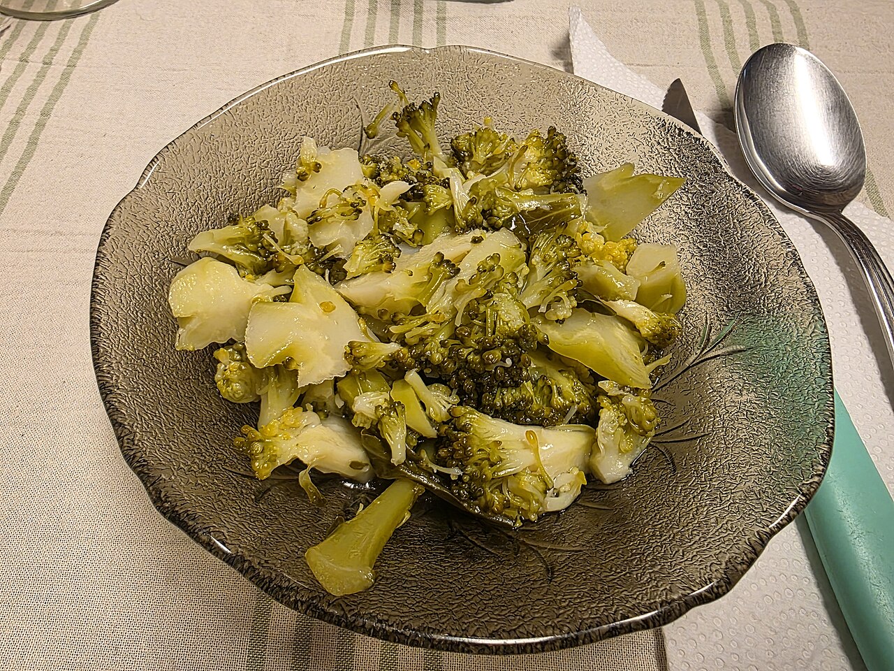 Cooked broccoli florets in a glass bowl