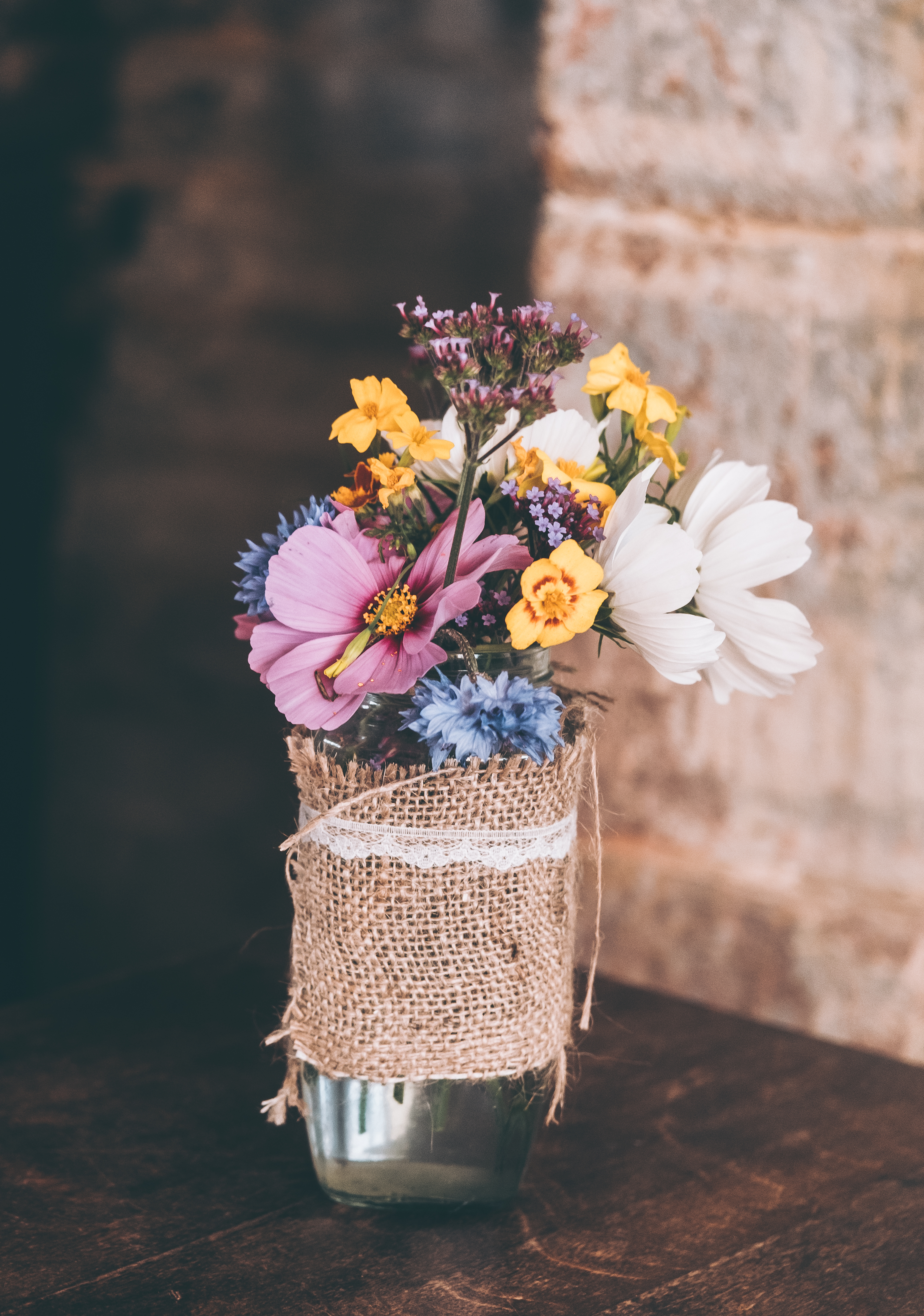 A vase of mixed cut flowers on a table