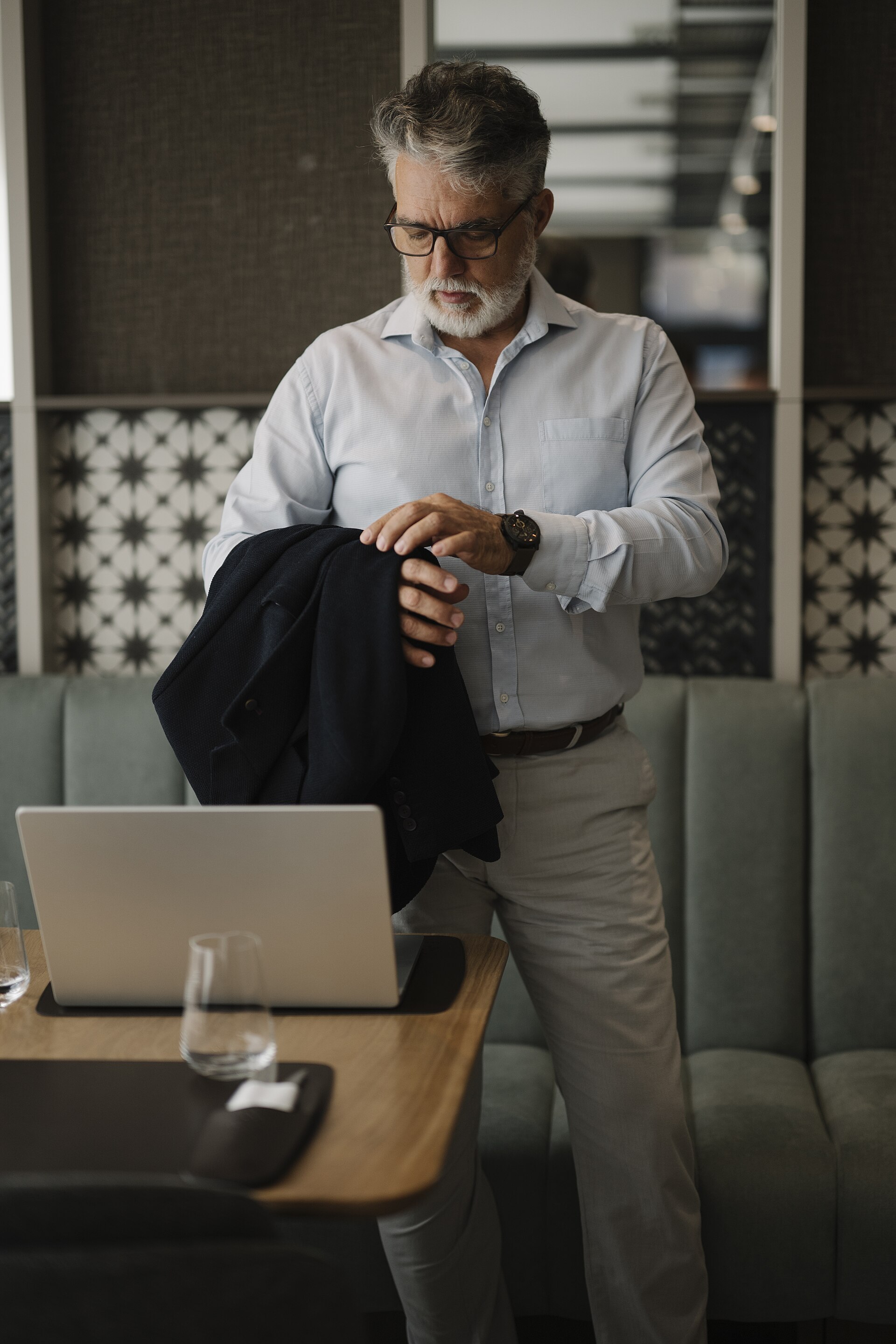 A person preparing for a meeting with a laptop on the table