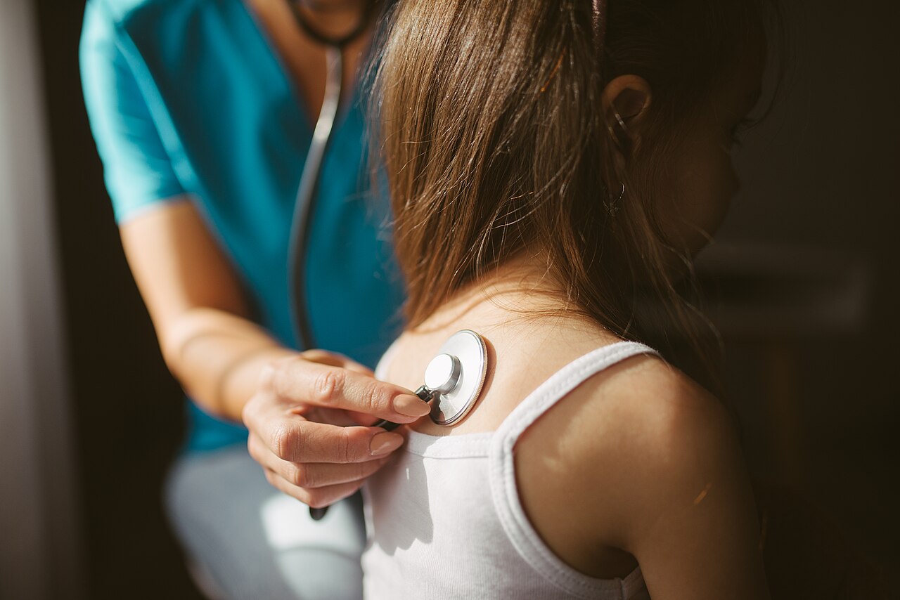 A doctor listening to a patient with a stethoscope
