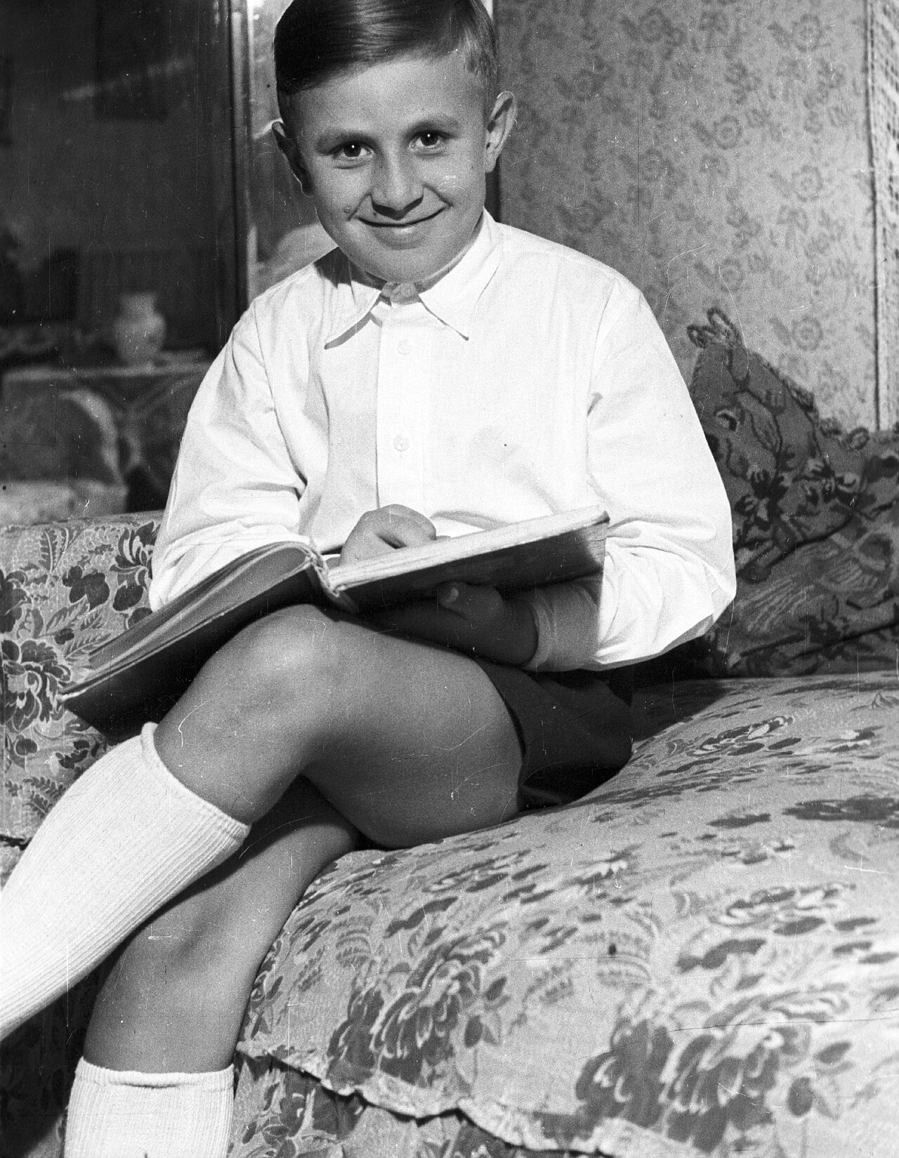 A boy reading a book on his own