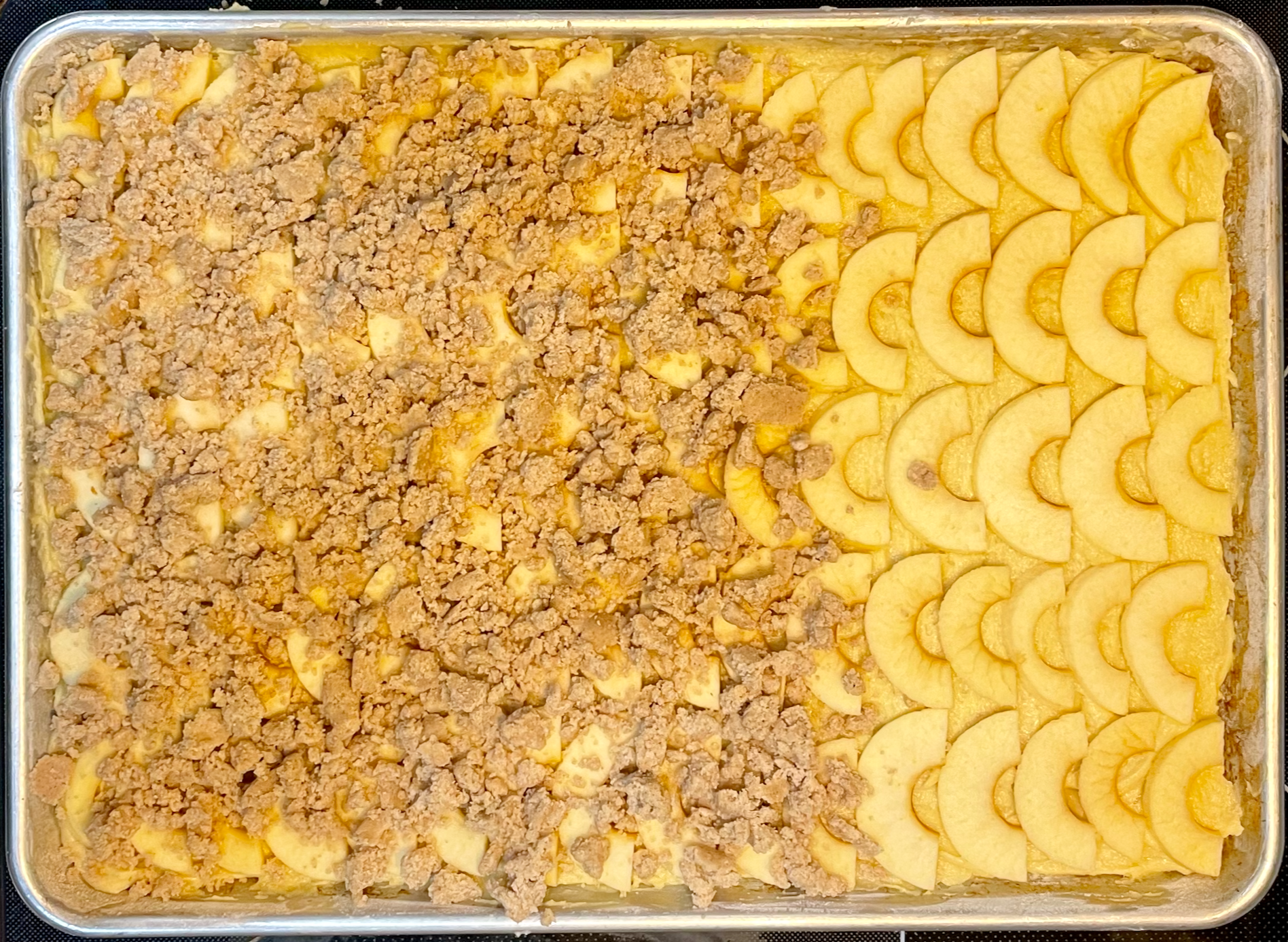 Raw cake batter being spread in a baking pan before going into the oven