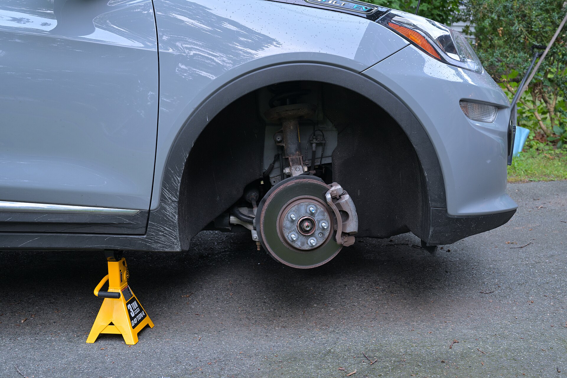 Car brake disc and caliper exposed with the wheel removed