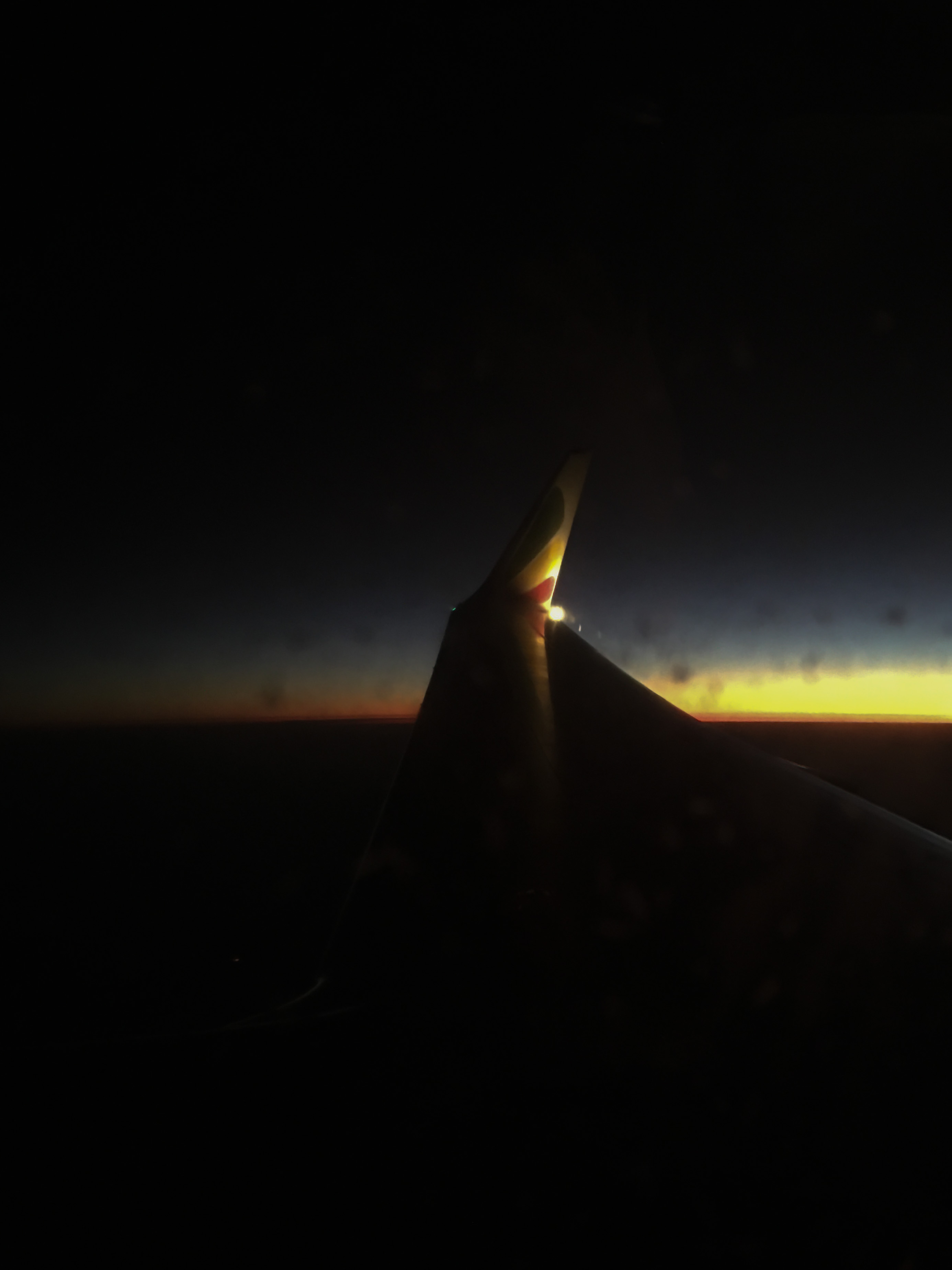 An airplane wing photographed through the cabin window in flight