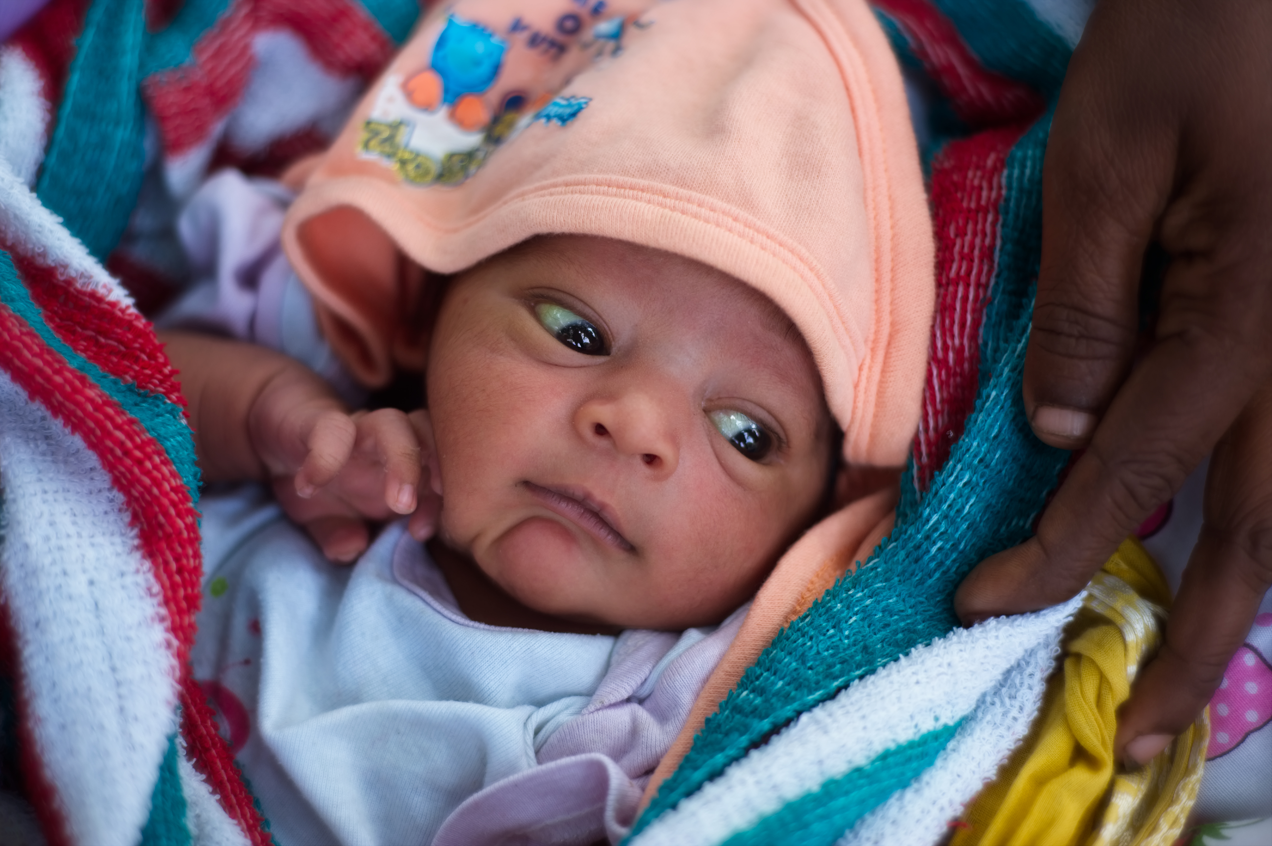 A newborn baby sleeping safely in a white blanket