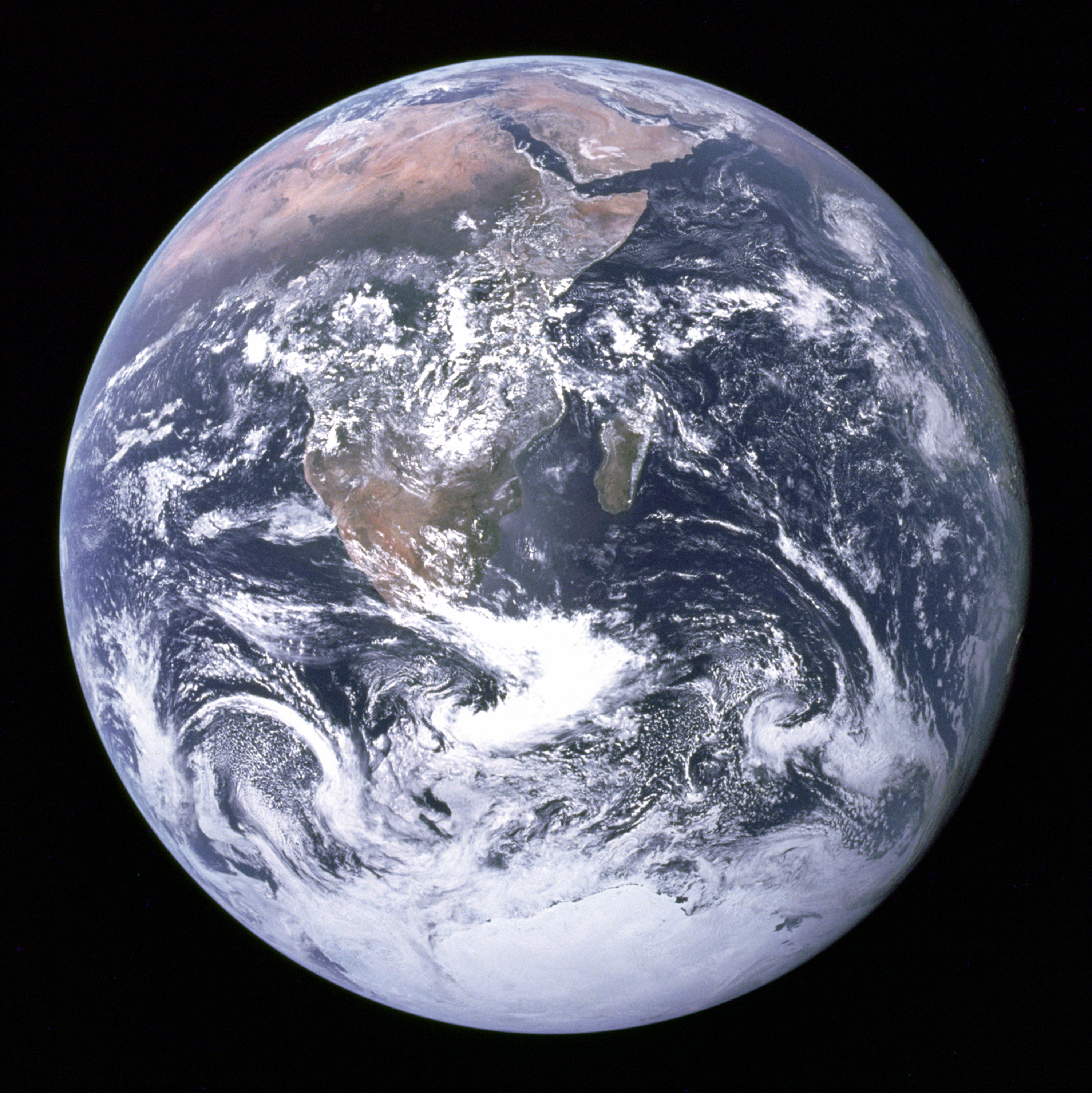 Photograph of Earth from space showing blue oceans, white clouds, and green-brown land