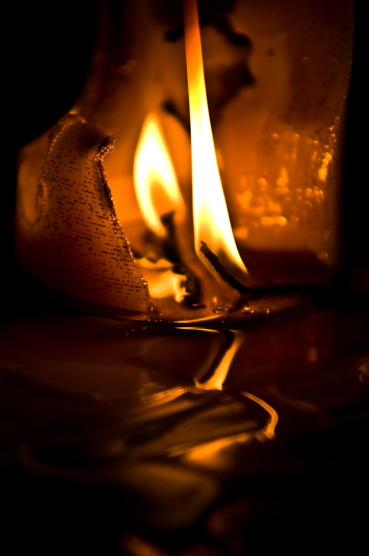 A burned-down candle with melted and spilled wax around its base