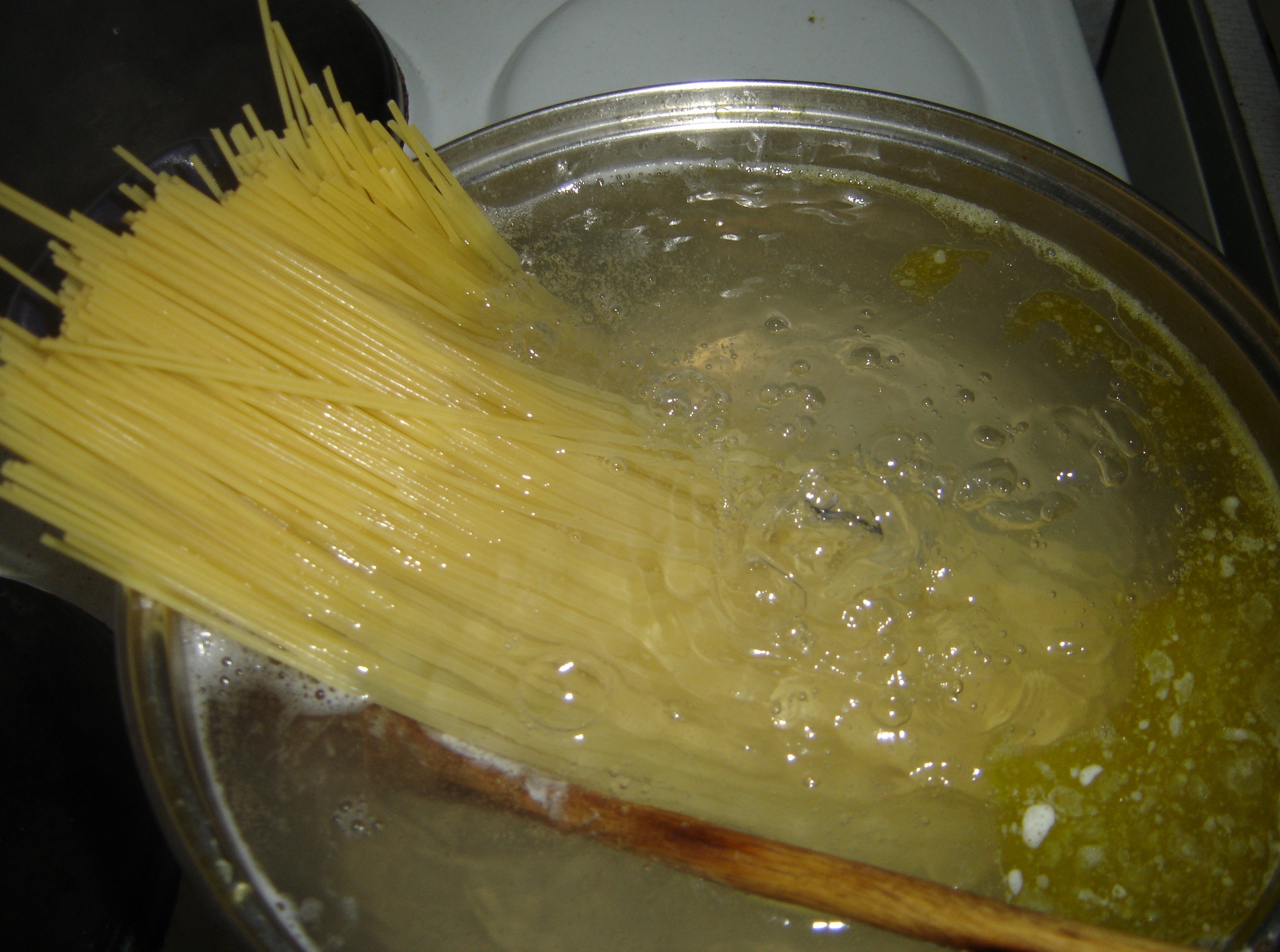Spaghetti cooking in a large pot of boiling water