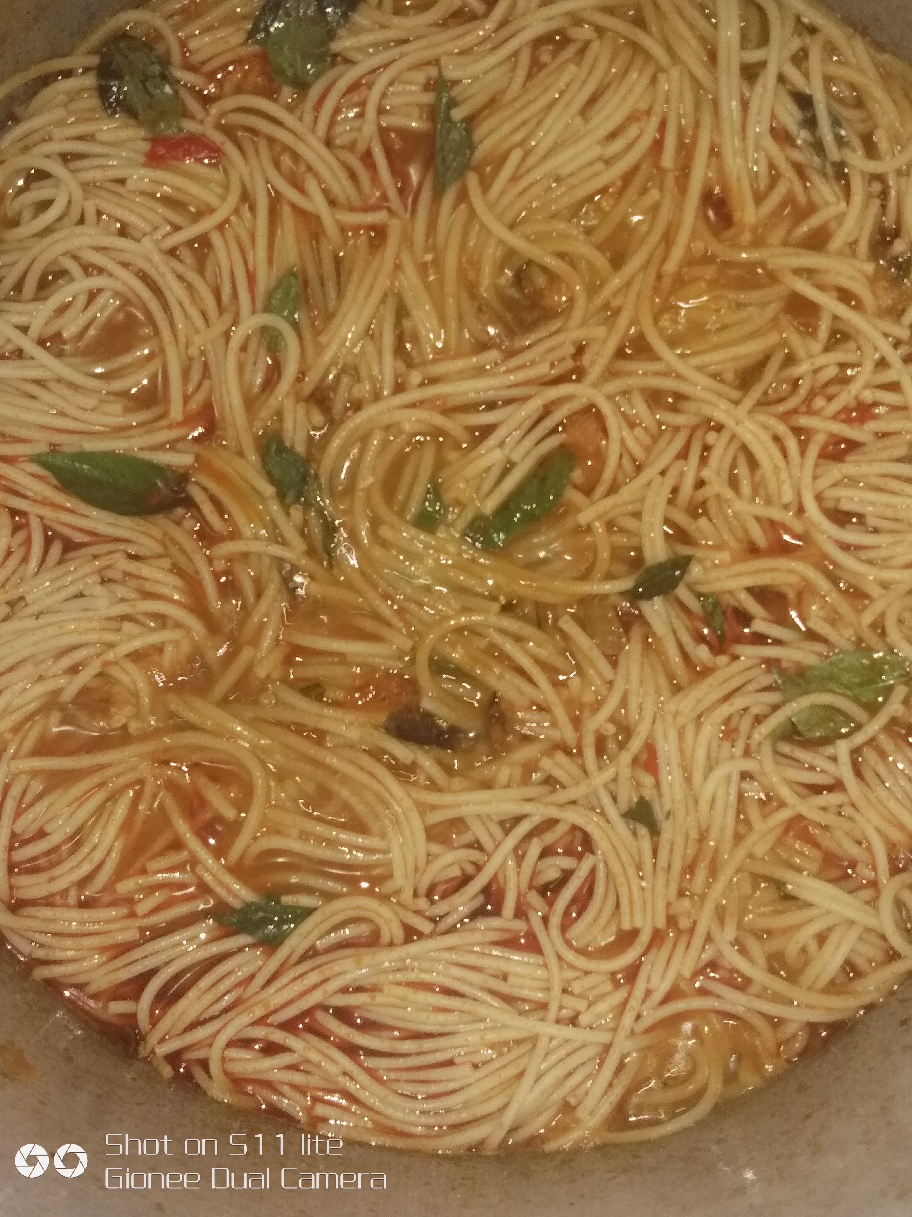 Spaghetti being lifted from boiling water during cooking
