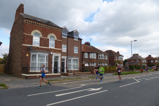 Marathon runners heading along a road during a city race