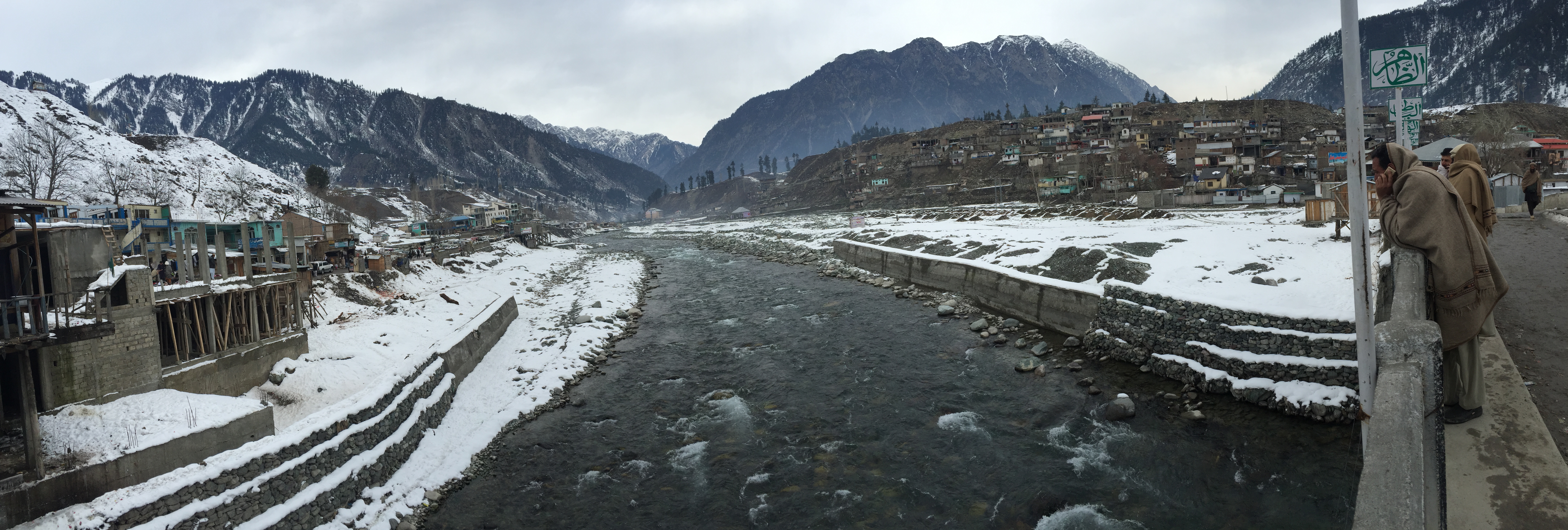 A river flowing between forested mountains in a wide valley